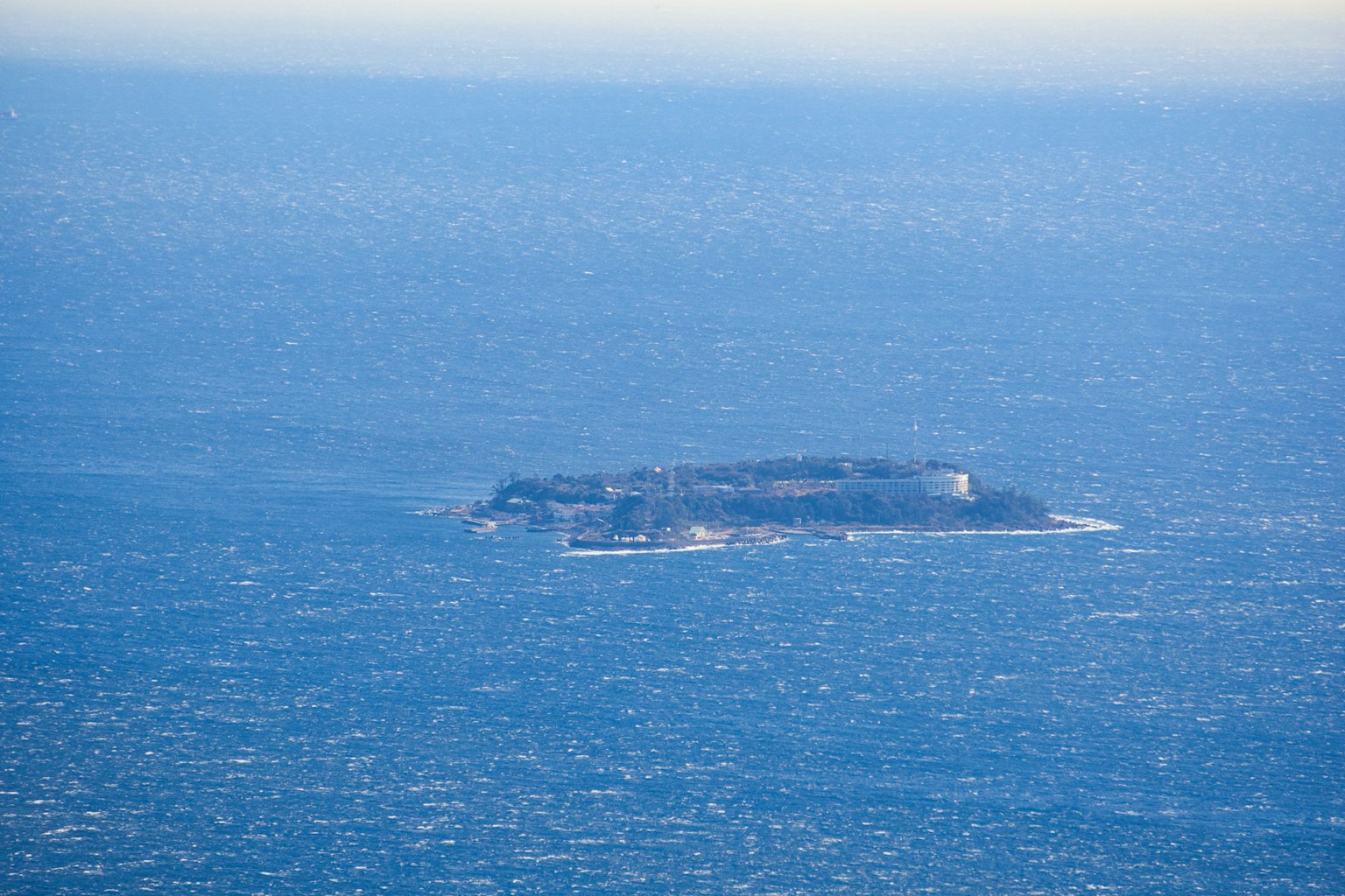 Aerial view of an island floating on blue waters