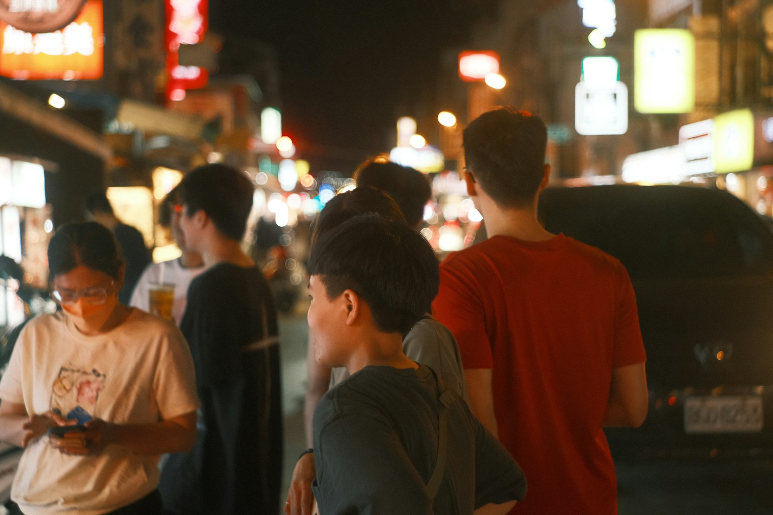 一群年轻人在夜晚繁忙的街道上站着