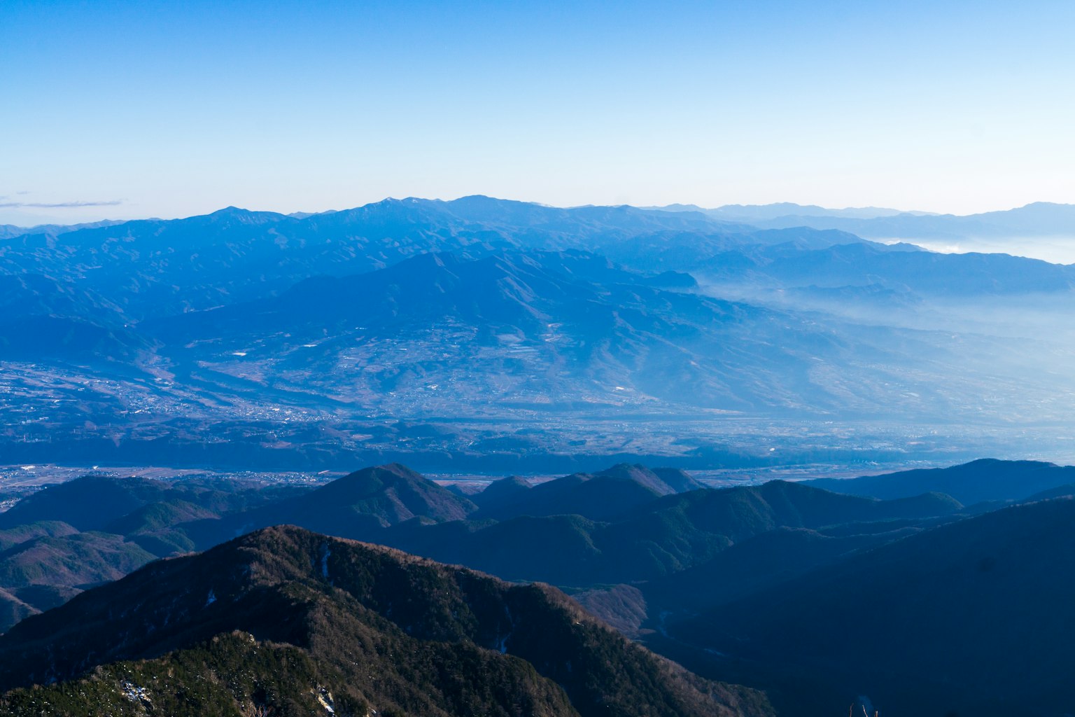 Pemandangan panorama pegunungan di bawah langit biru yang cerah