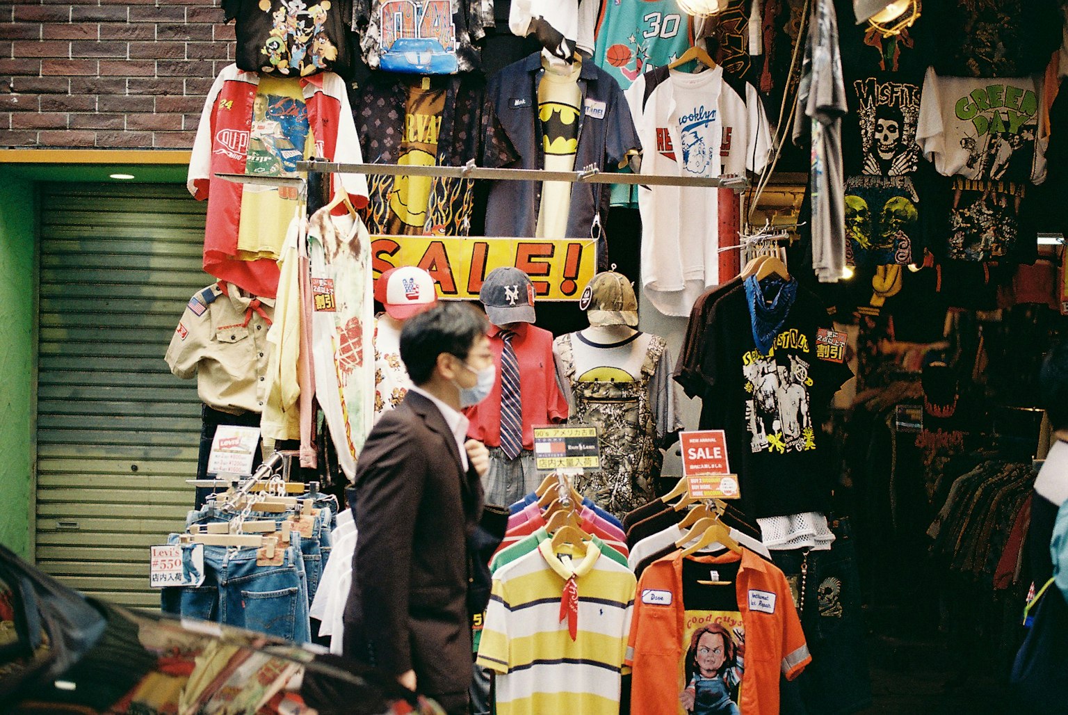 一名男子走過一家充滿多彩T恤的戶外服裝店
