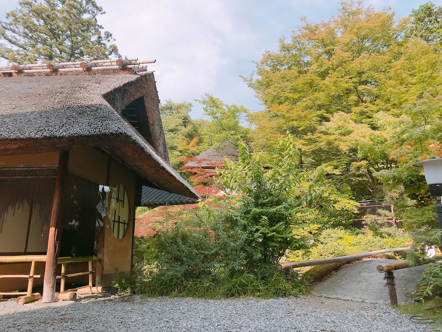 Casa giapponese tradizionale circondata da una lussureggiante vegetazione e un sentiero di ghiaia