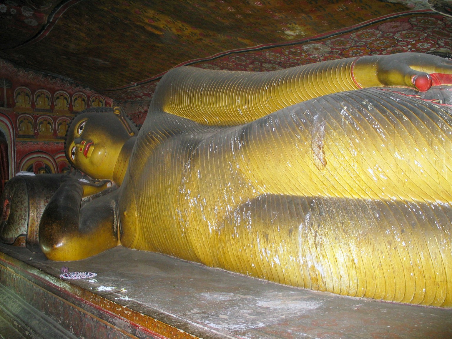Golden reclining Buddha statue inside a cave