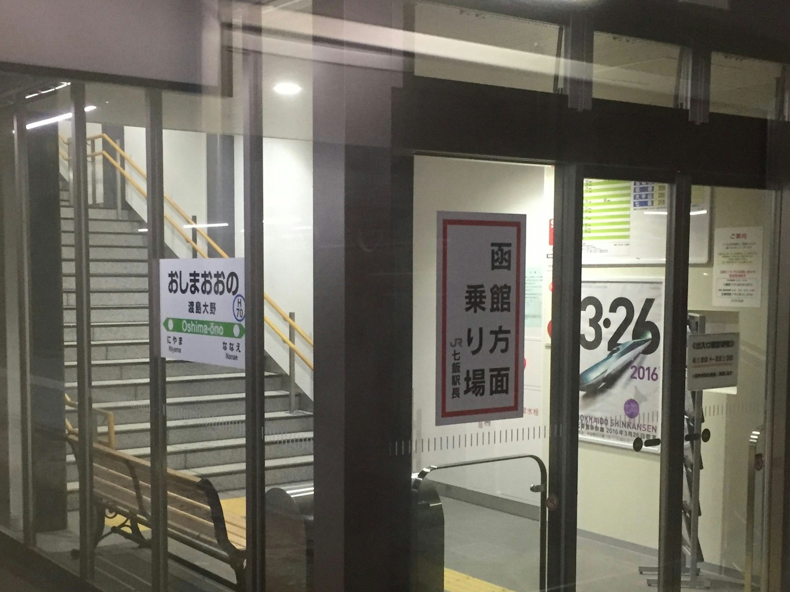 Außenansicht eines Gebäudes mit Glastüren und Treppen, die farbenfrohe Plakate zeigen