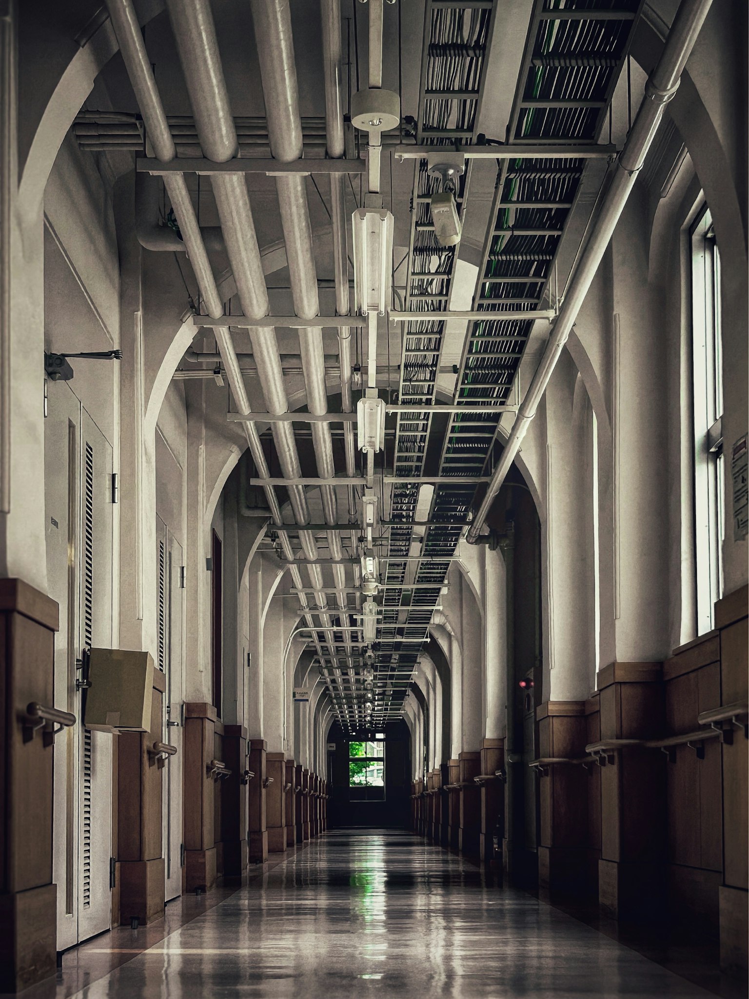 長い廊下が見える建物の内部 白い壁と天井 照明が並ぶ