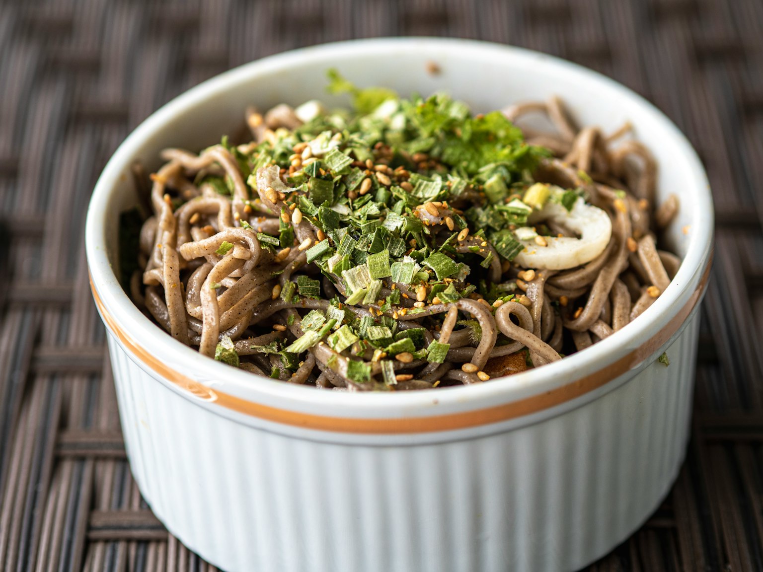 Tazón de fideos soba cubiertos con cebollino picado y semillas de sésamo