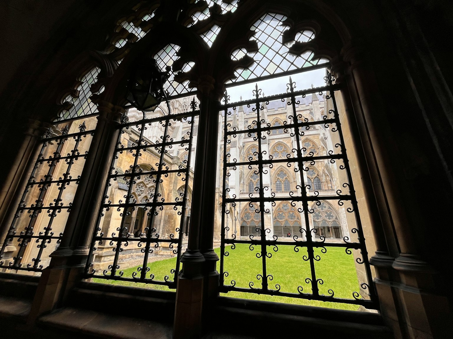 Blick auf einen Innenhof durch ein gotisches Fenster