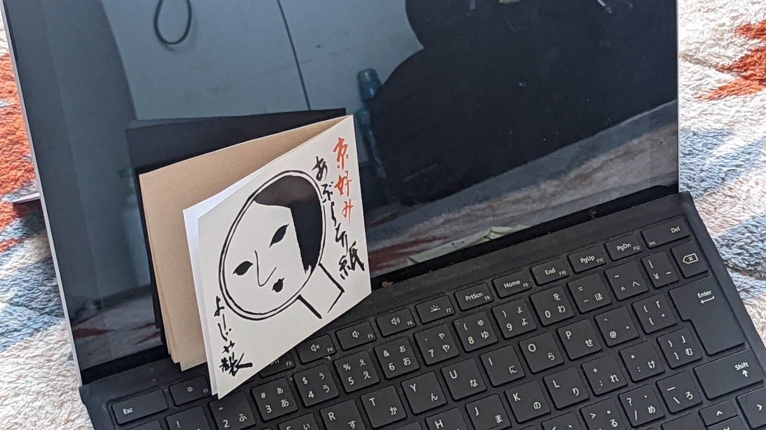 Un pequeño libro hecho a mano colocado sobre una laptop mostrando su diseño
