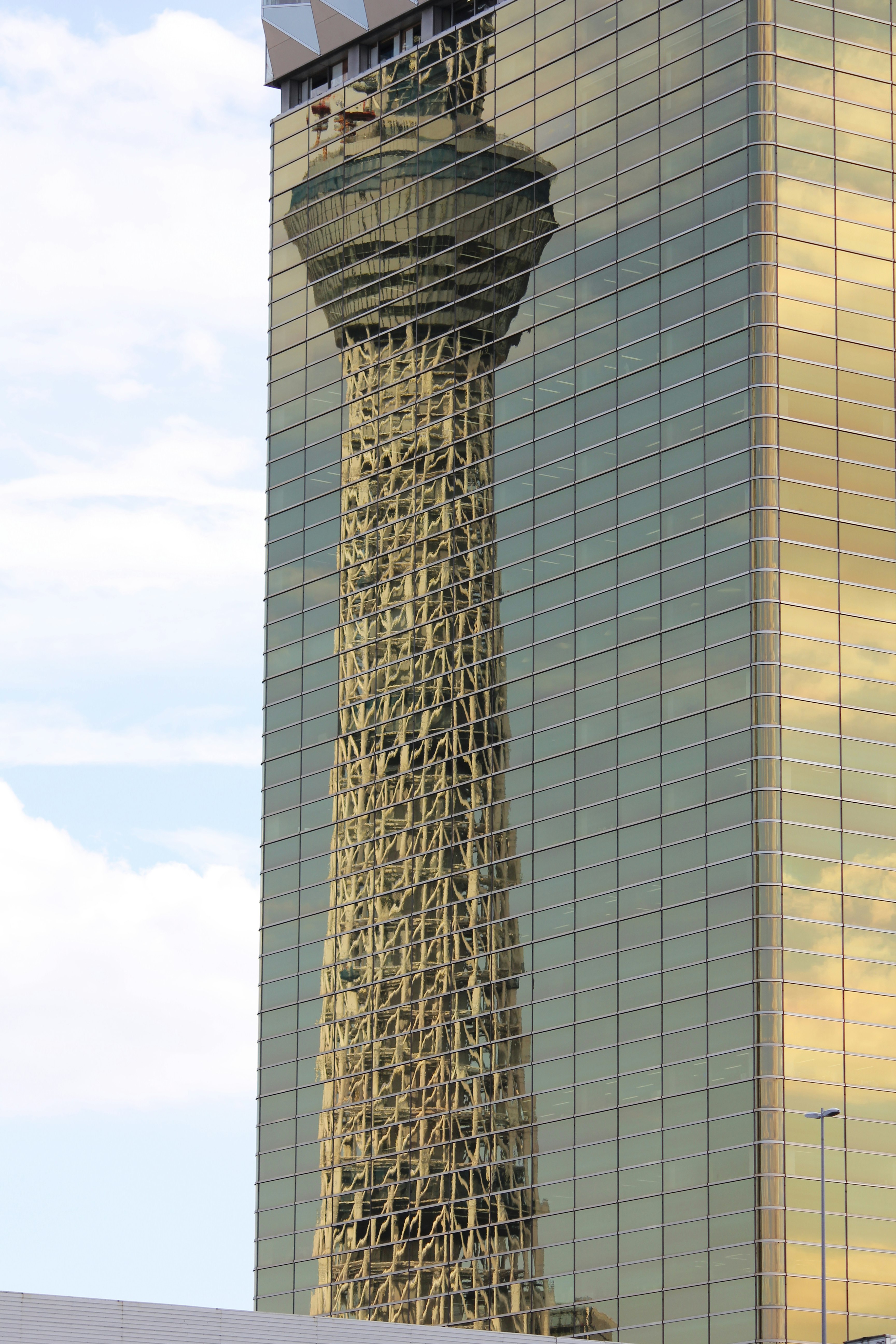 ガラス張りの高層ビルに絡む金属格子の外観