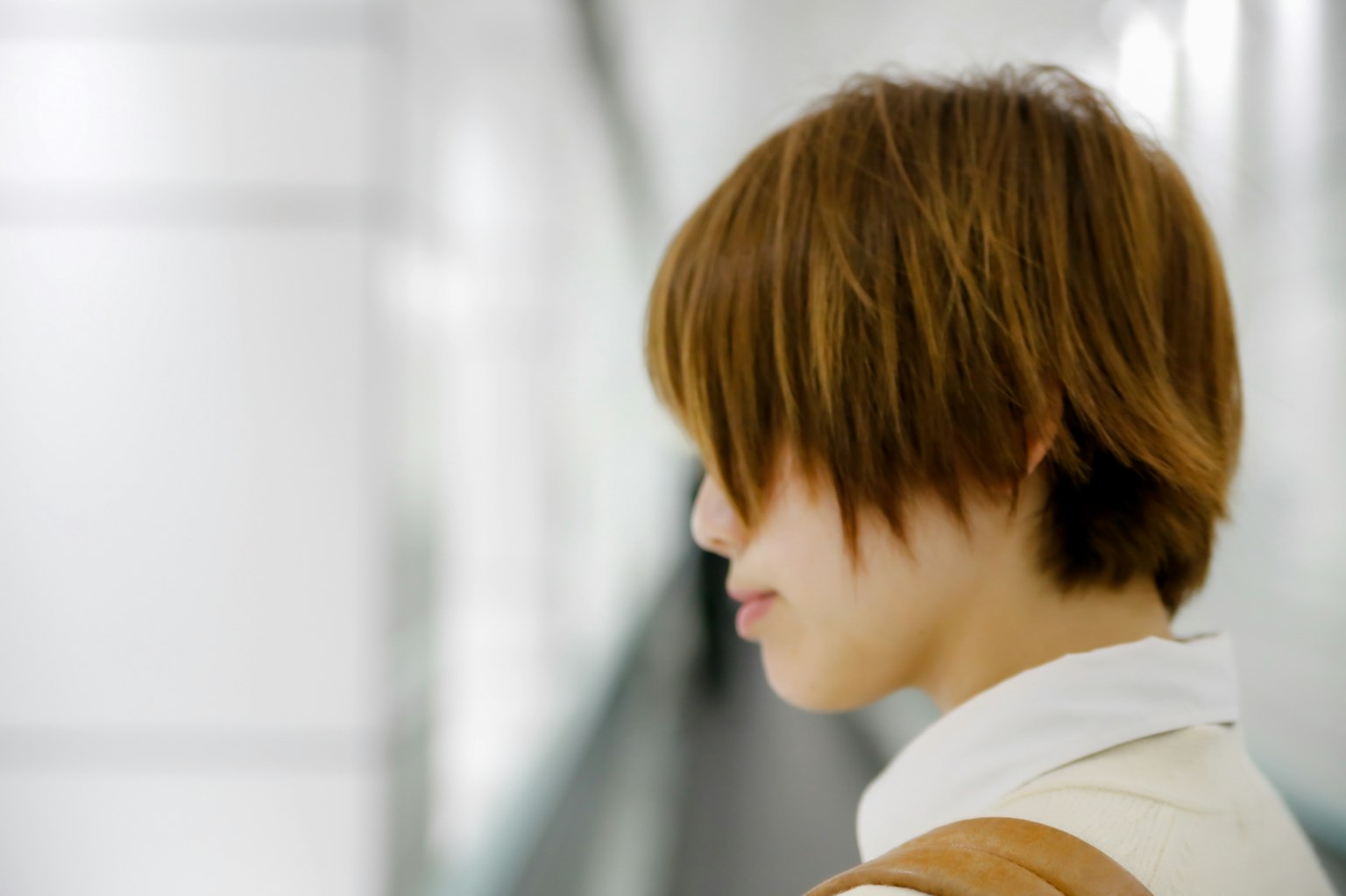 Joven mujer con cabello corto de perfil en un entorno interior moderno