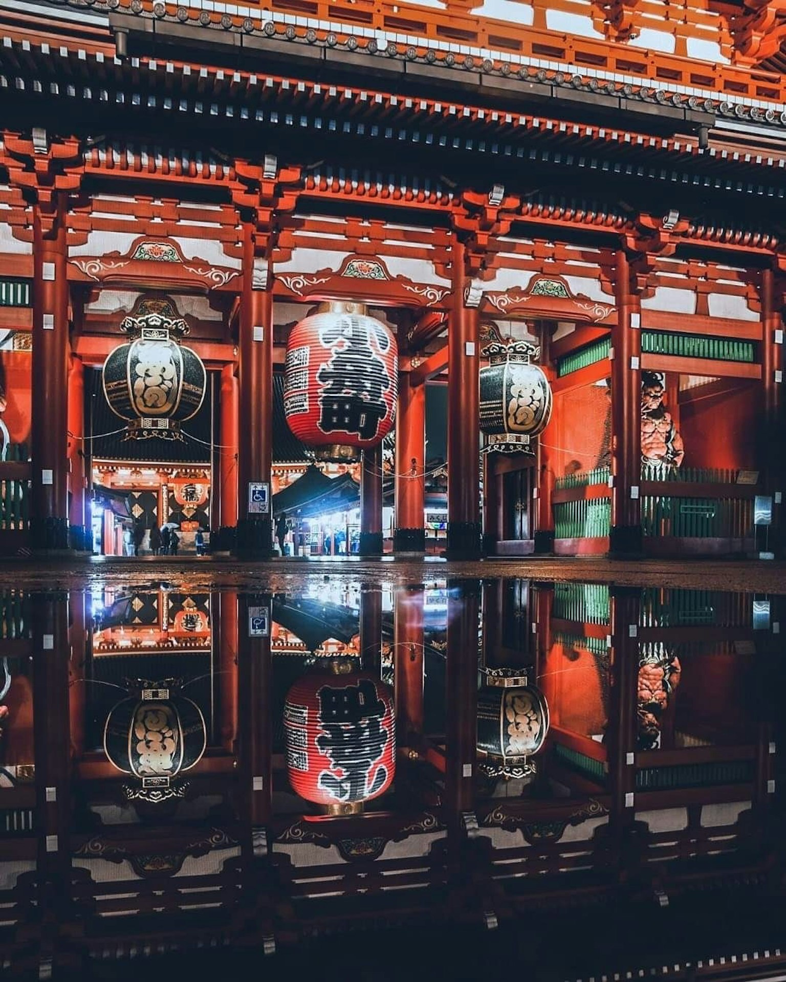 Vista nocturna de un santuario japonés tradicional con pilares rojos y grandes faroles Bella reflexión en la superficie del agua