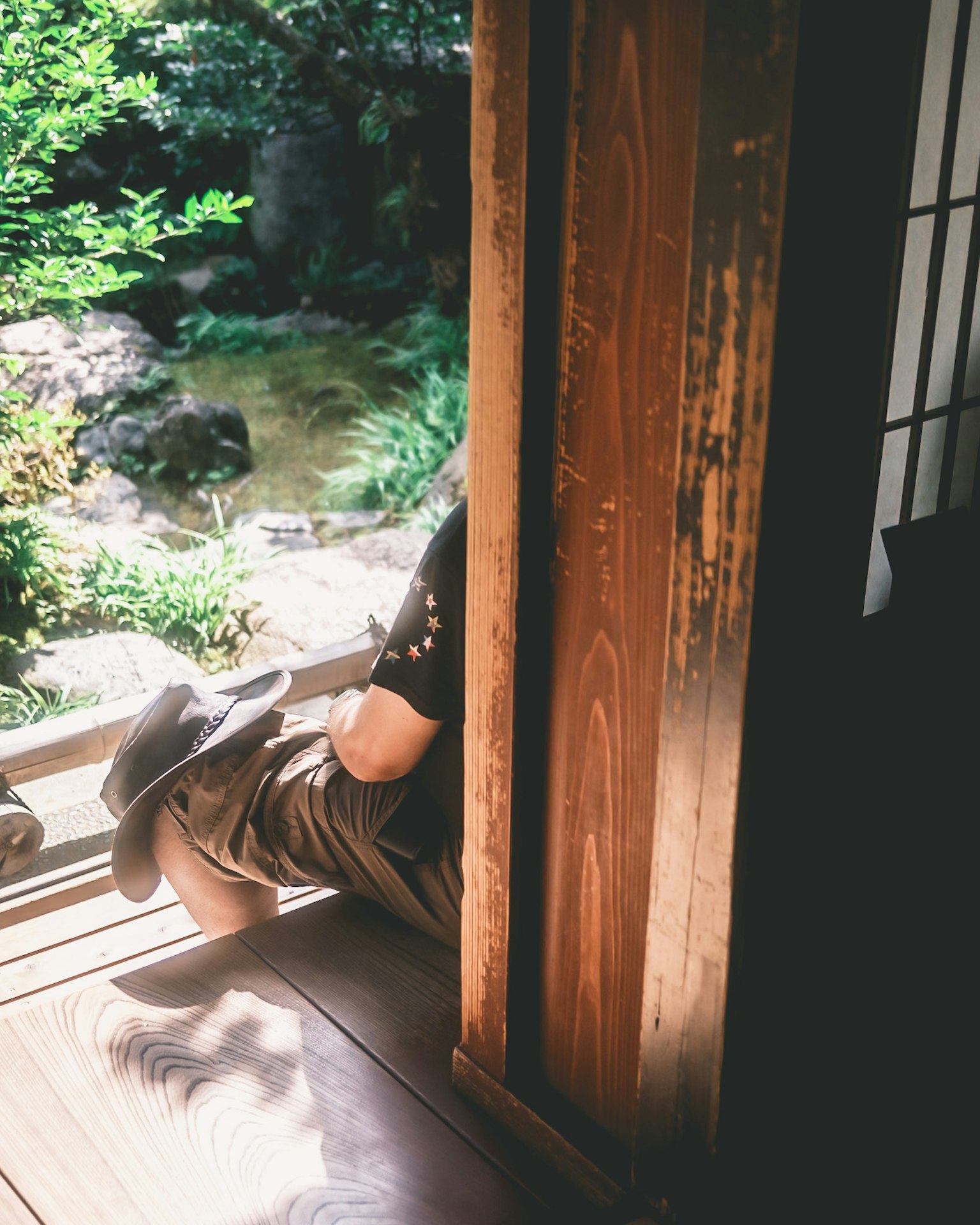 Eine Person sitzt in einem traditionellen Raum mit Blick auf einen japanischen Garten