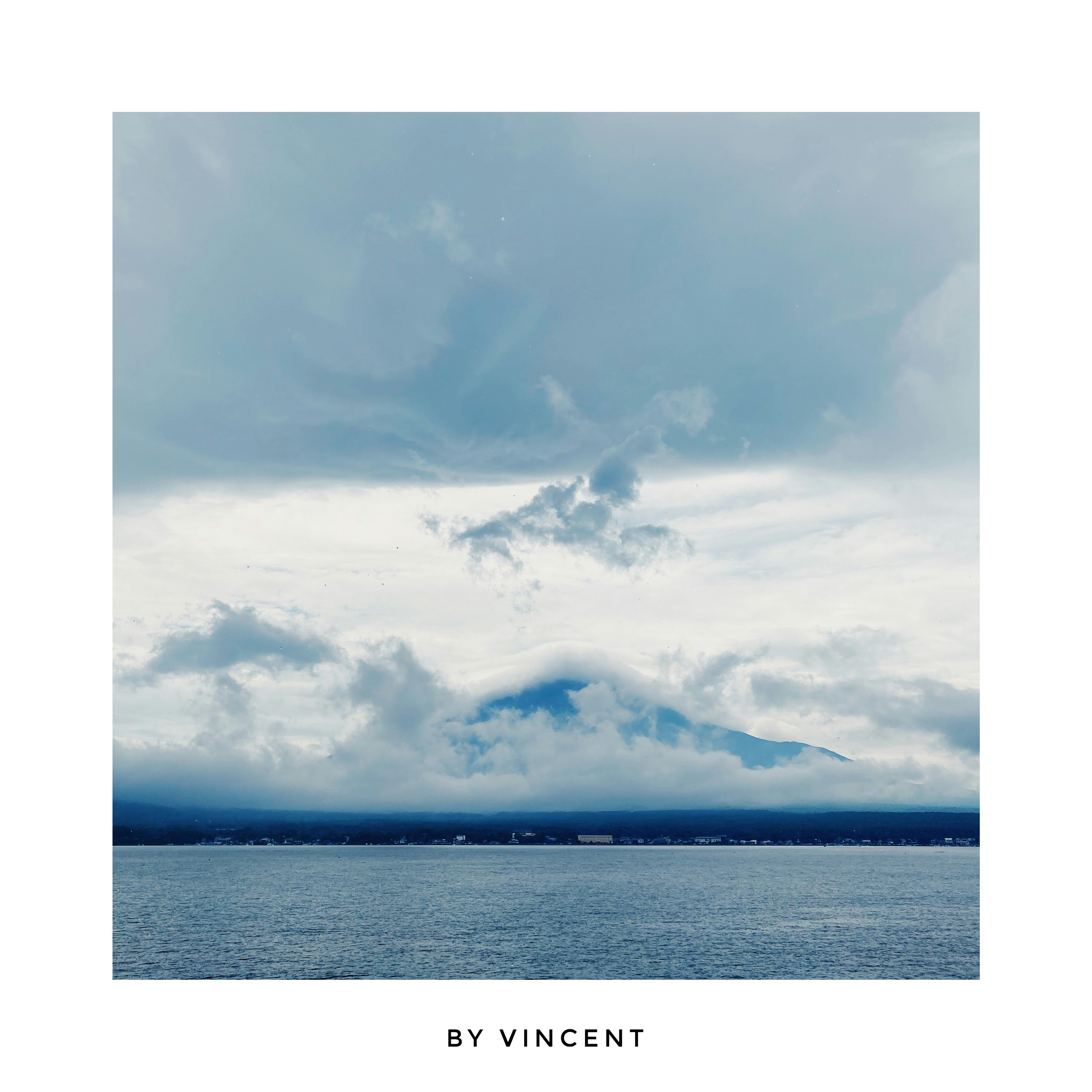 cloudy sky over the sea with a Mount Fuji-like silhouette