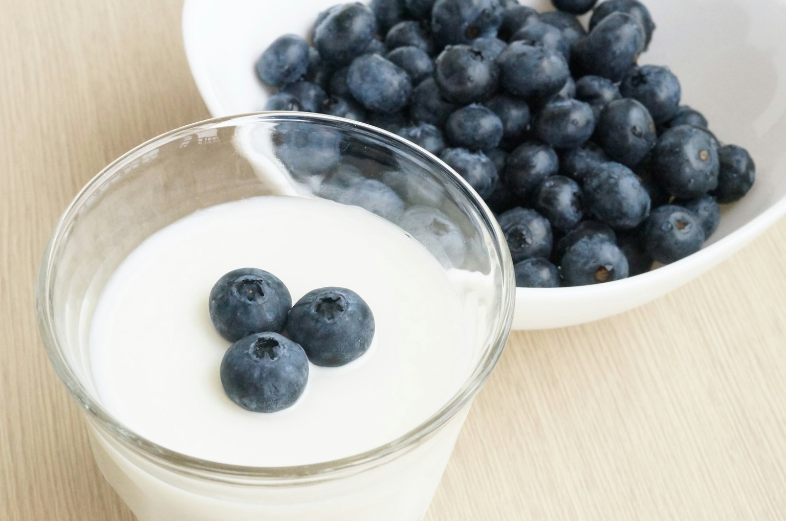 Yogur cremoso cubierto con arándanos frescos en un vaso