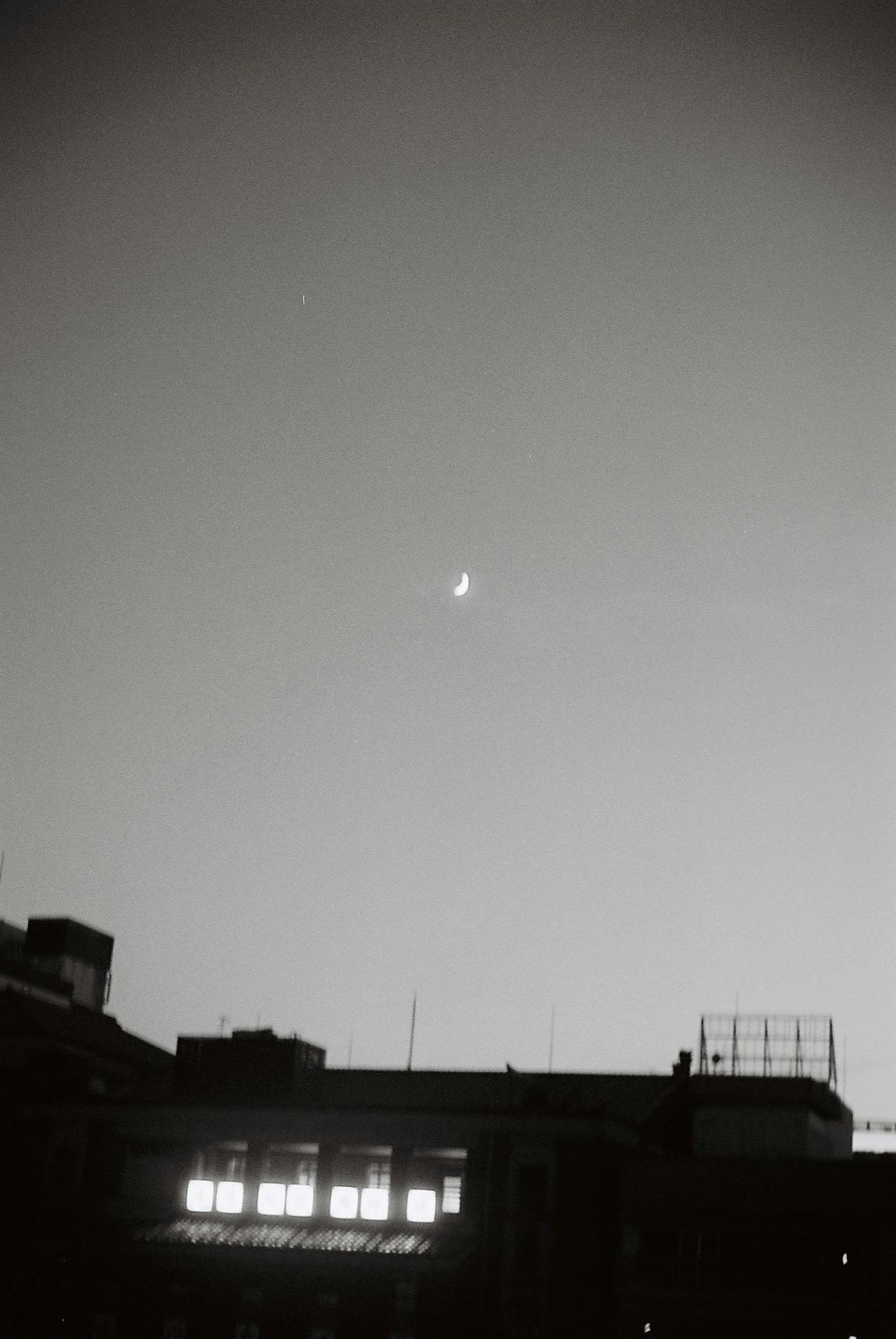Lune croissante au-dessus de la silhouette de la ville au crépuscule