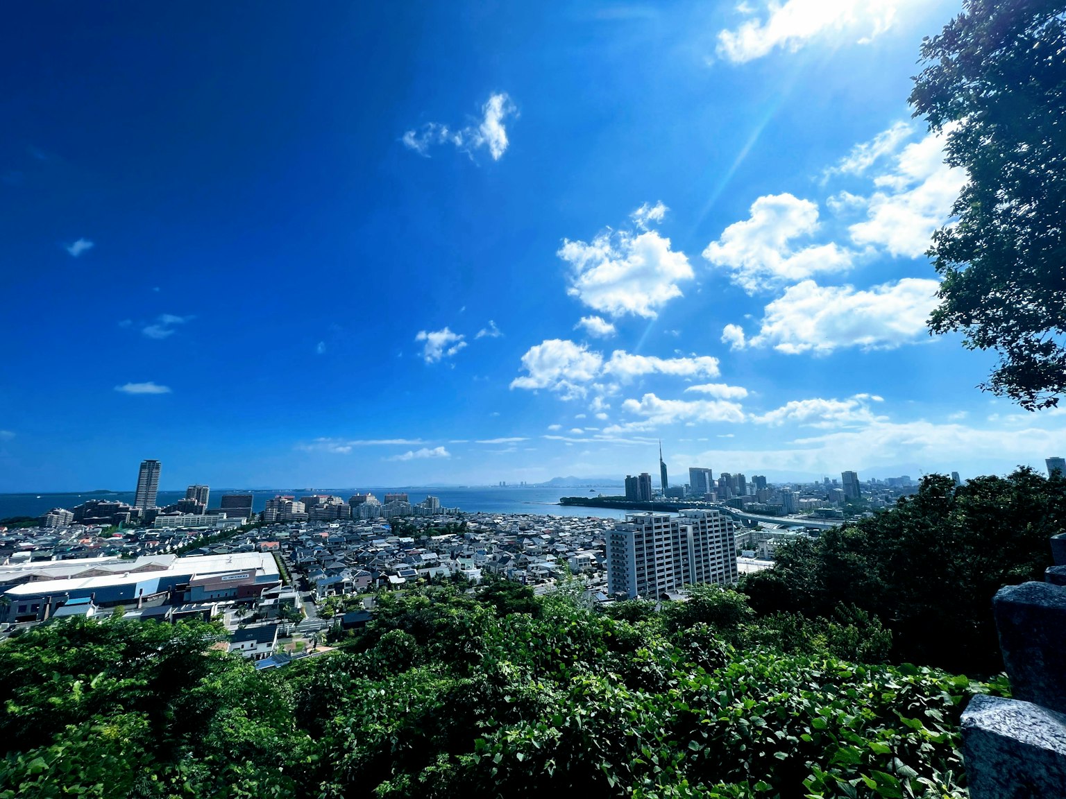 Vista panorámica de una ciudad bajo un cielo azul brillante con nubes dispersas