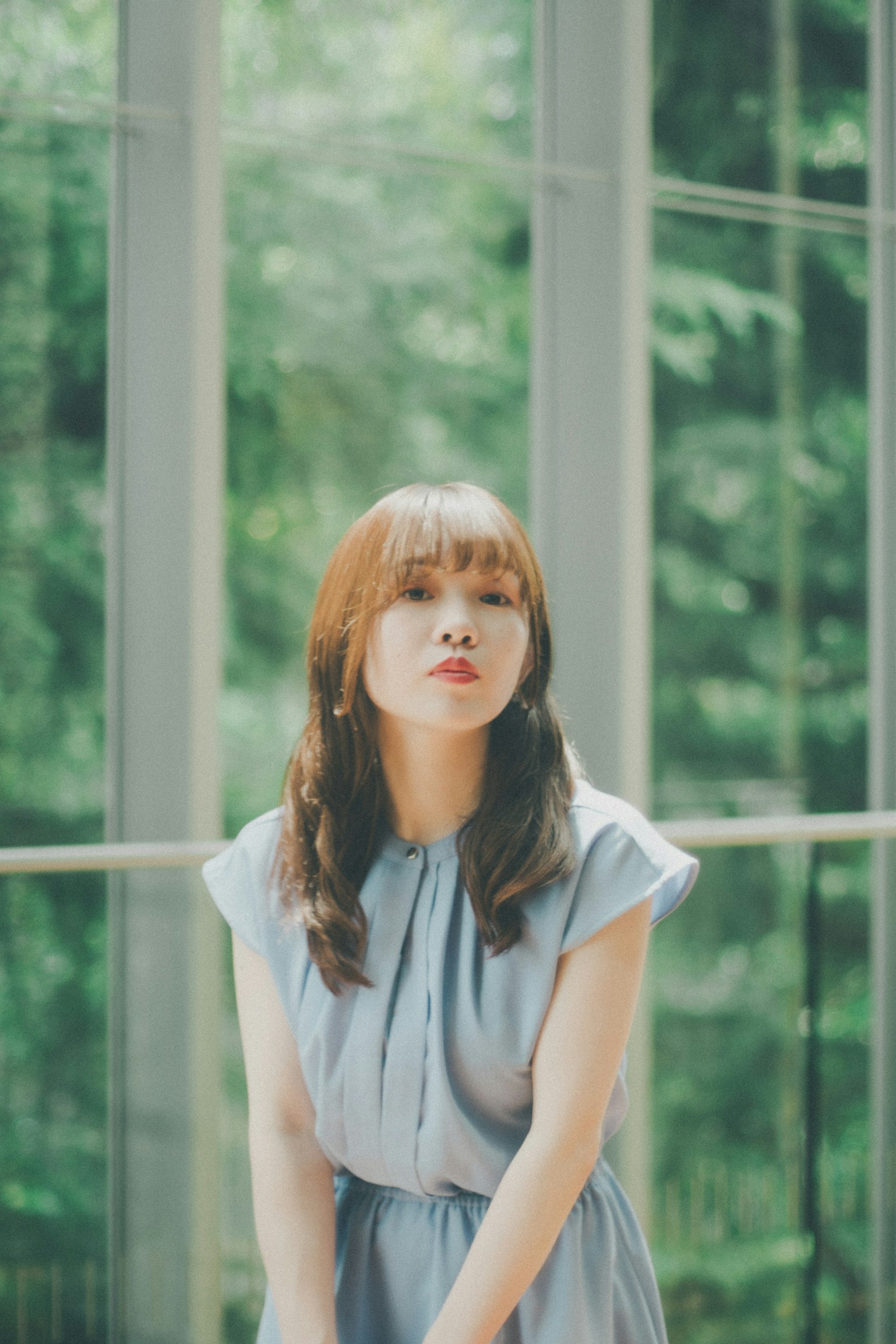 자연광 속에서 파란 드레스를 입은 여성의 포즈