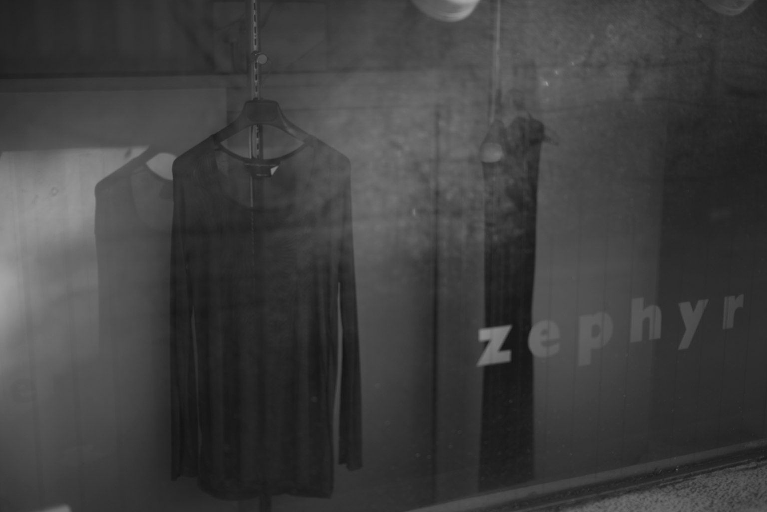 A photo of black clothing hanging on a rack with the word Zephyr visible
