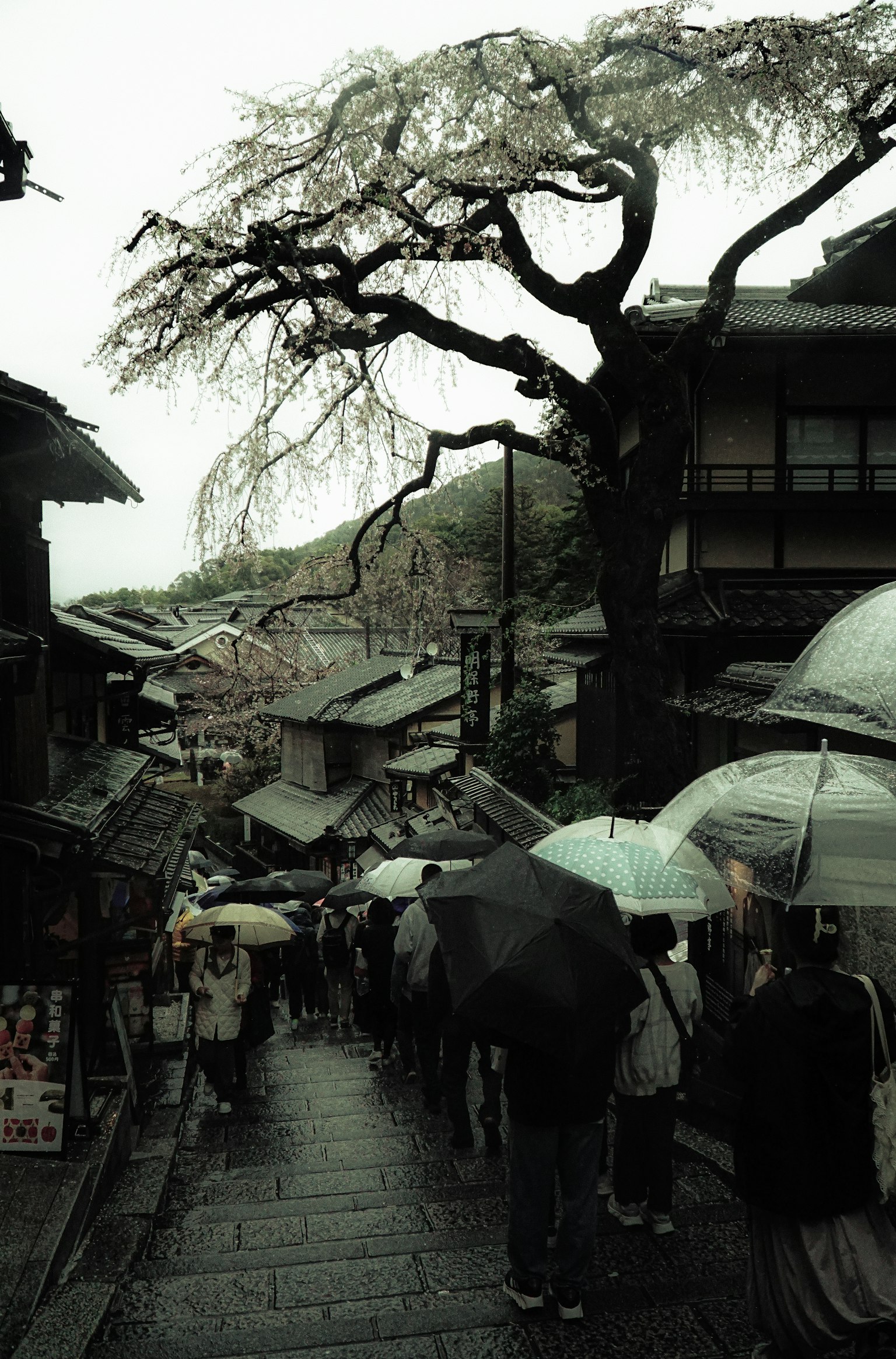 Old street scene with people holding umbrellas in the rain