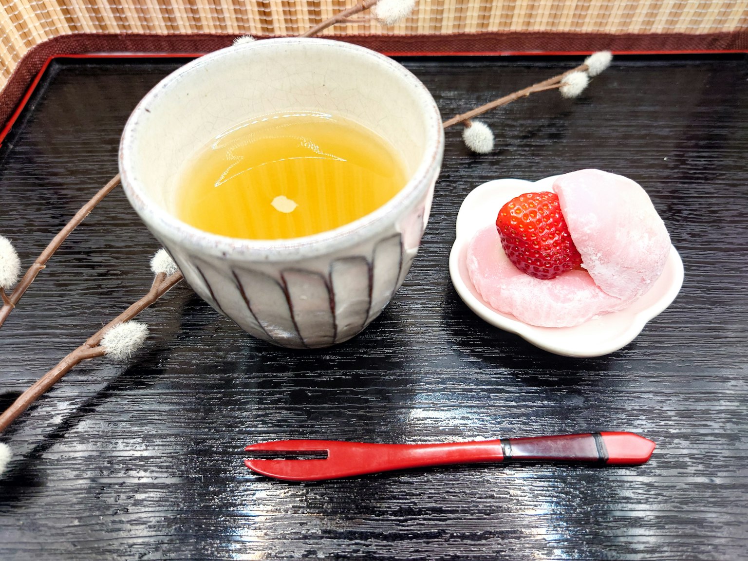 Une présentation de thé traditionnel avec du matcha et un dessert à la fraise