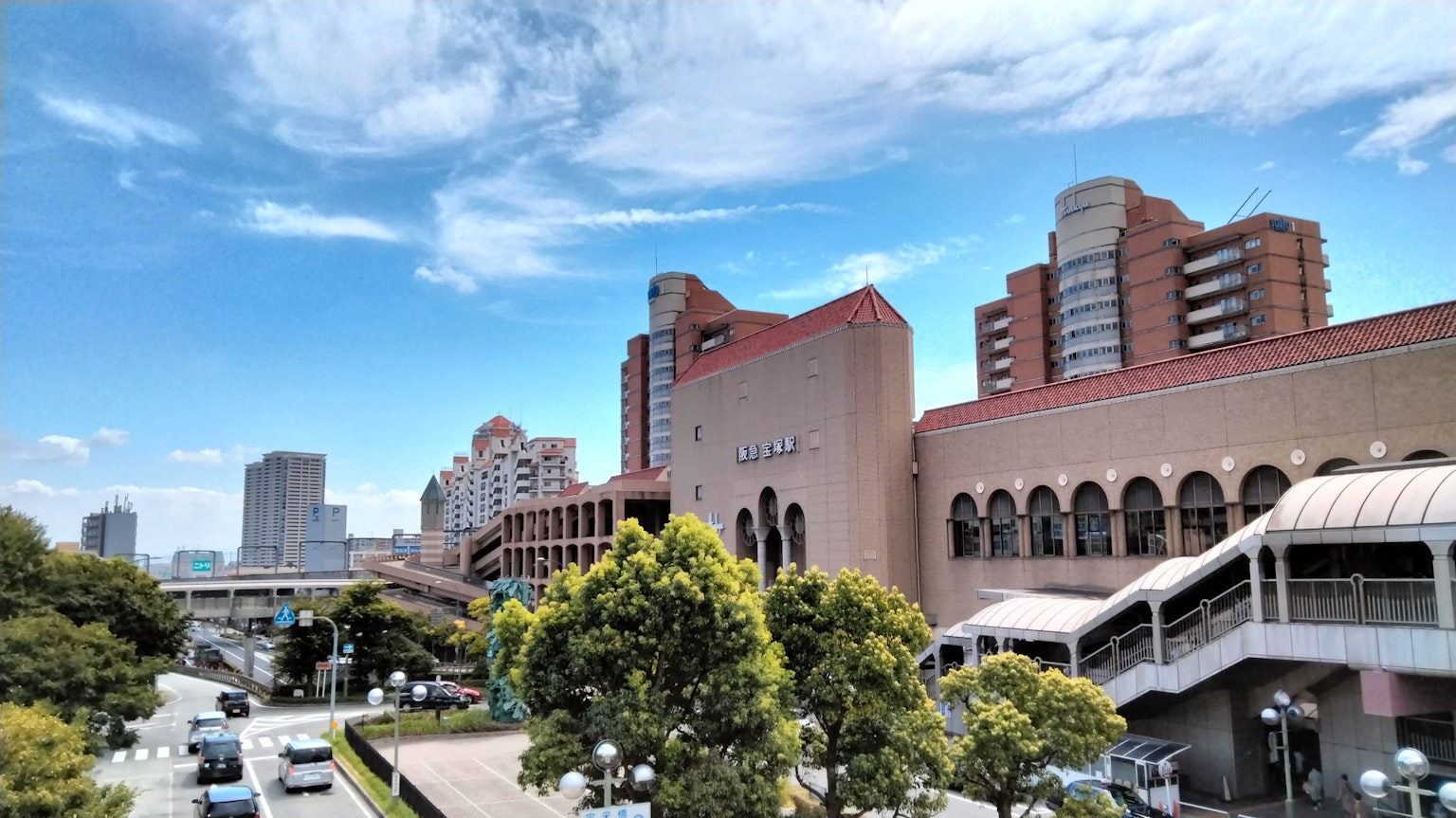 Paisaje urbano con edificios modernos y árboles verdes bajo un cielo azul