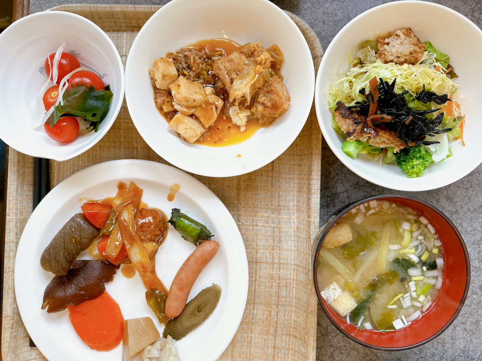 Un conjunto de platos coloridos servidos en cuencos y un plato blanco con varios alimentos