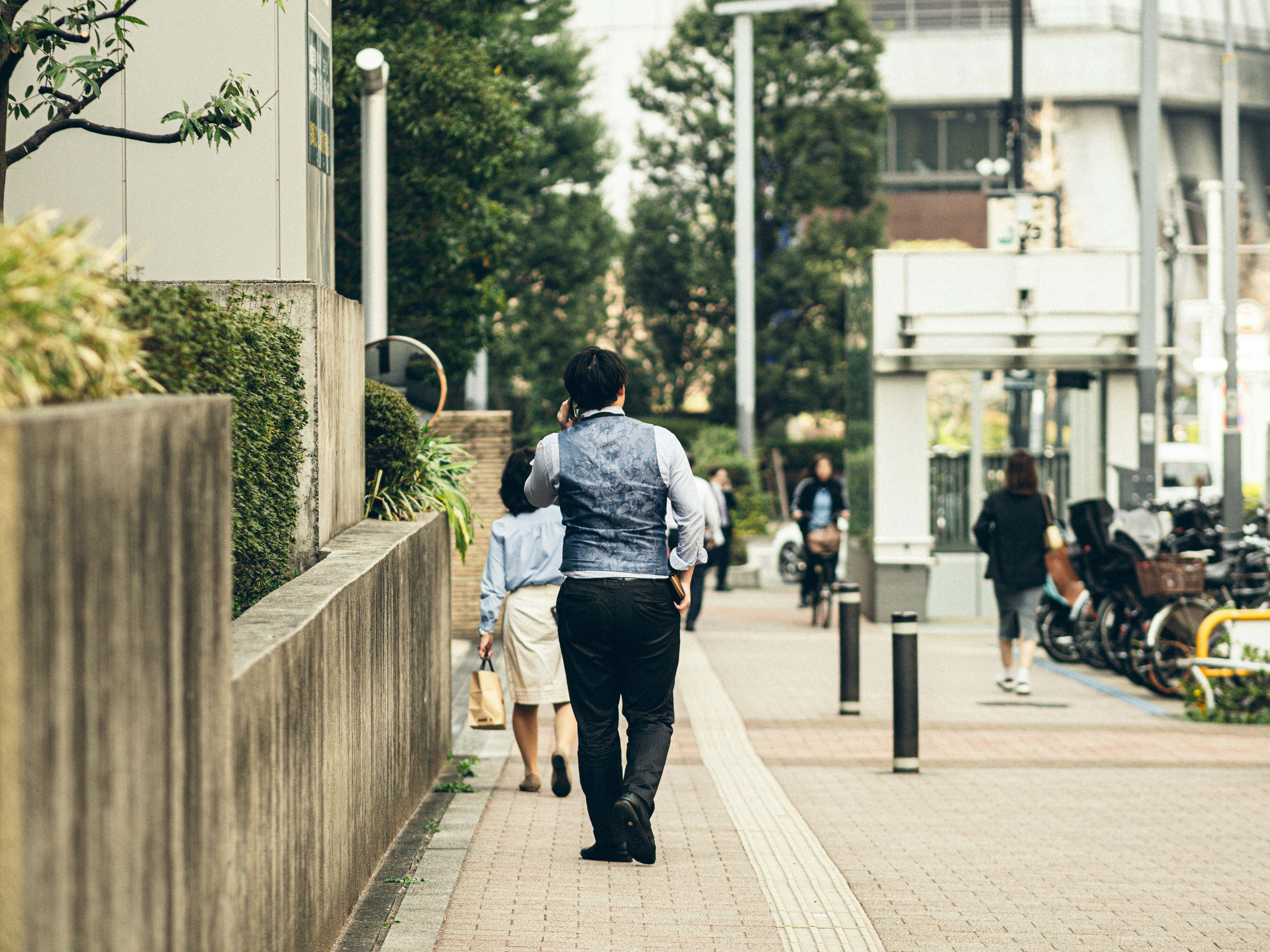 黄砂の中を歩く人々がいる街の歩道