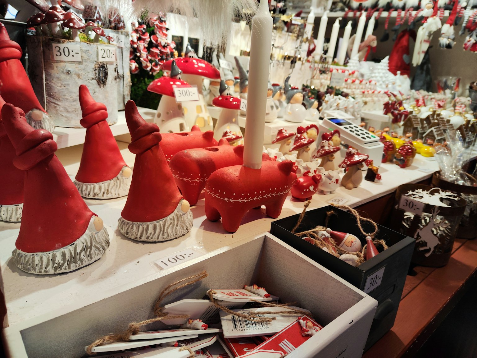 Christmas market display with red Santa hat decorations and candles