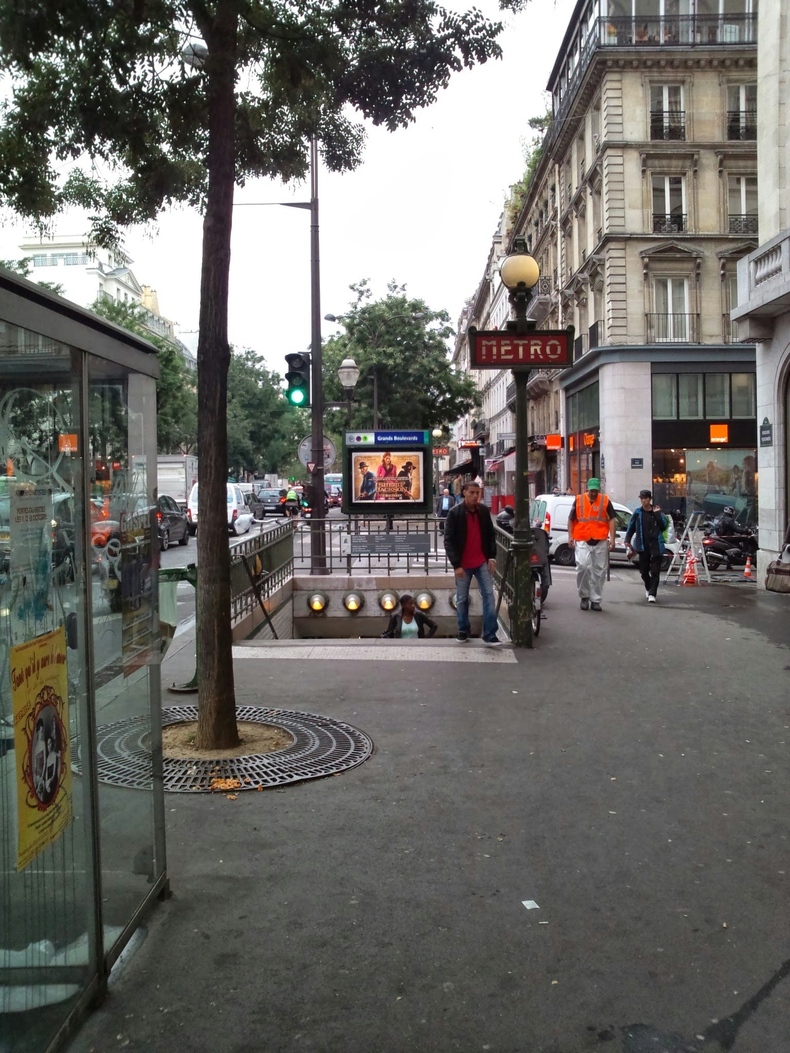 View of a Paris Metro entrance with street scene and pedestrians