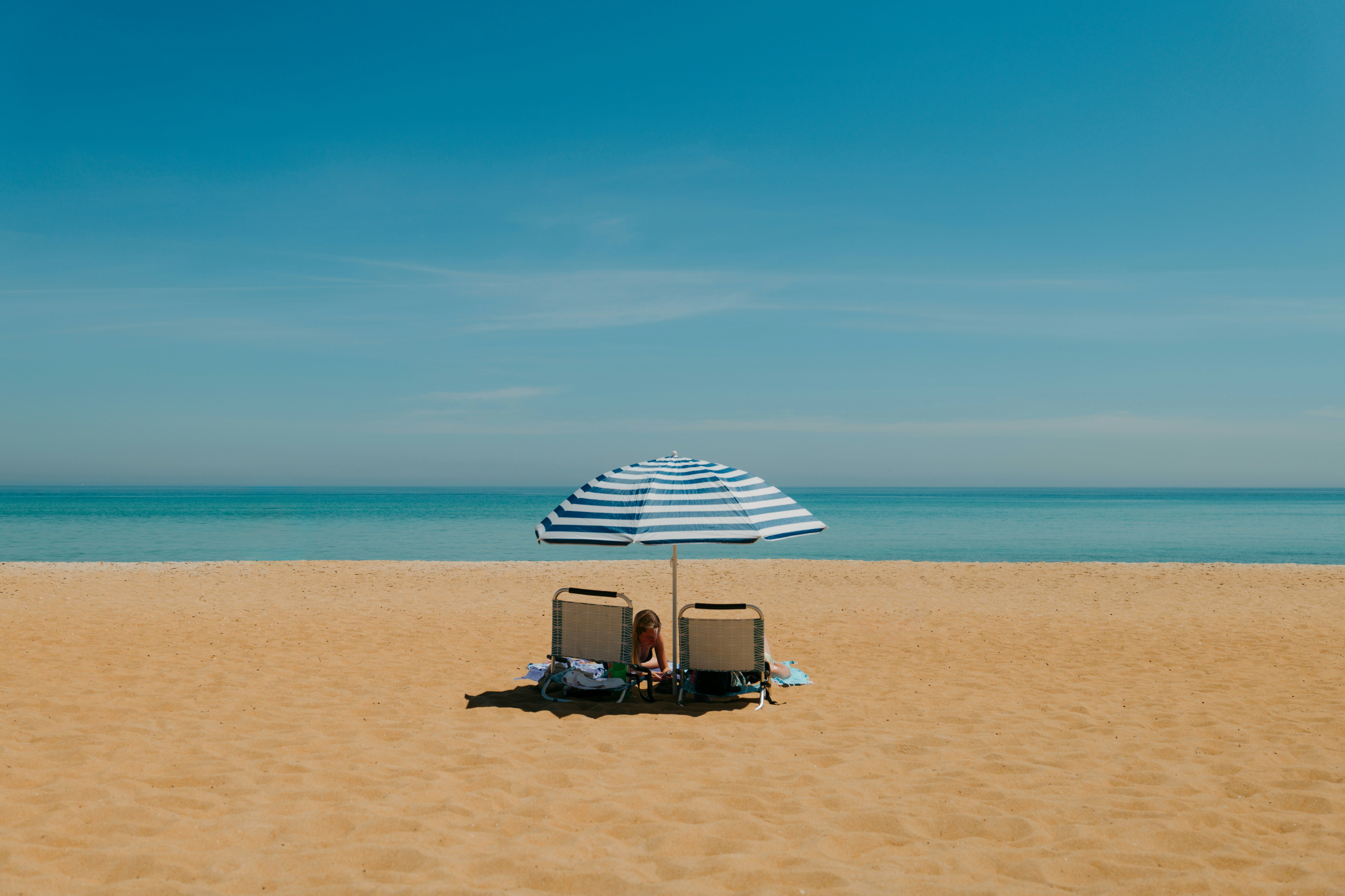ombrellone da spiaggia e sedie su una spiaggia di sabbia vicino al mare