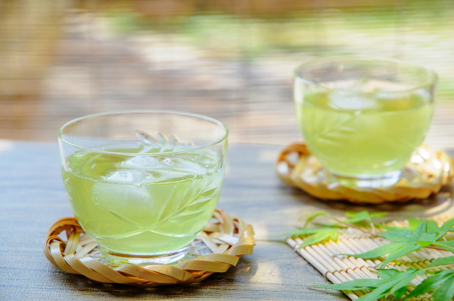 Hai ly trà xanh đá trên đế lót bằng tre