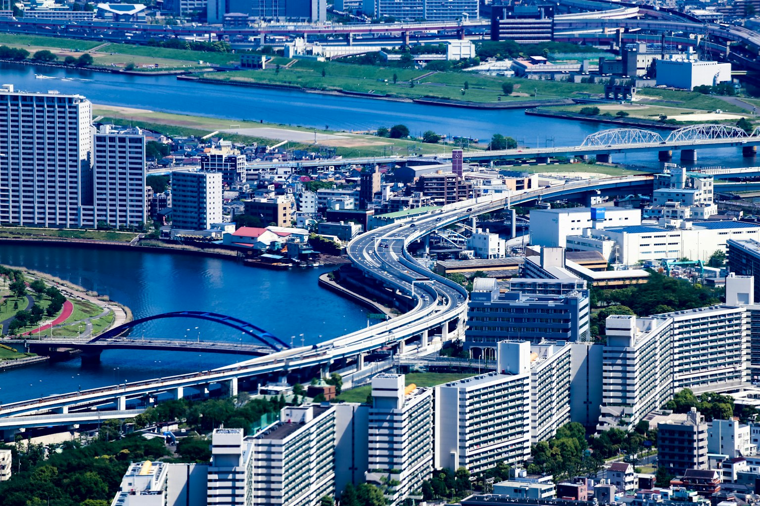 Urban landscape featuring high-rise buildings and a river with distinct traffic flow and bridges