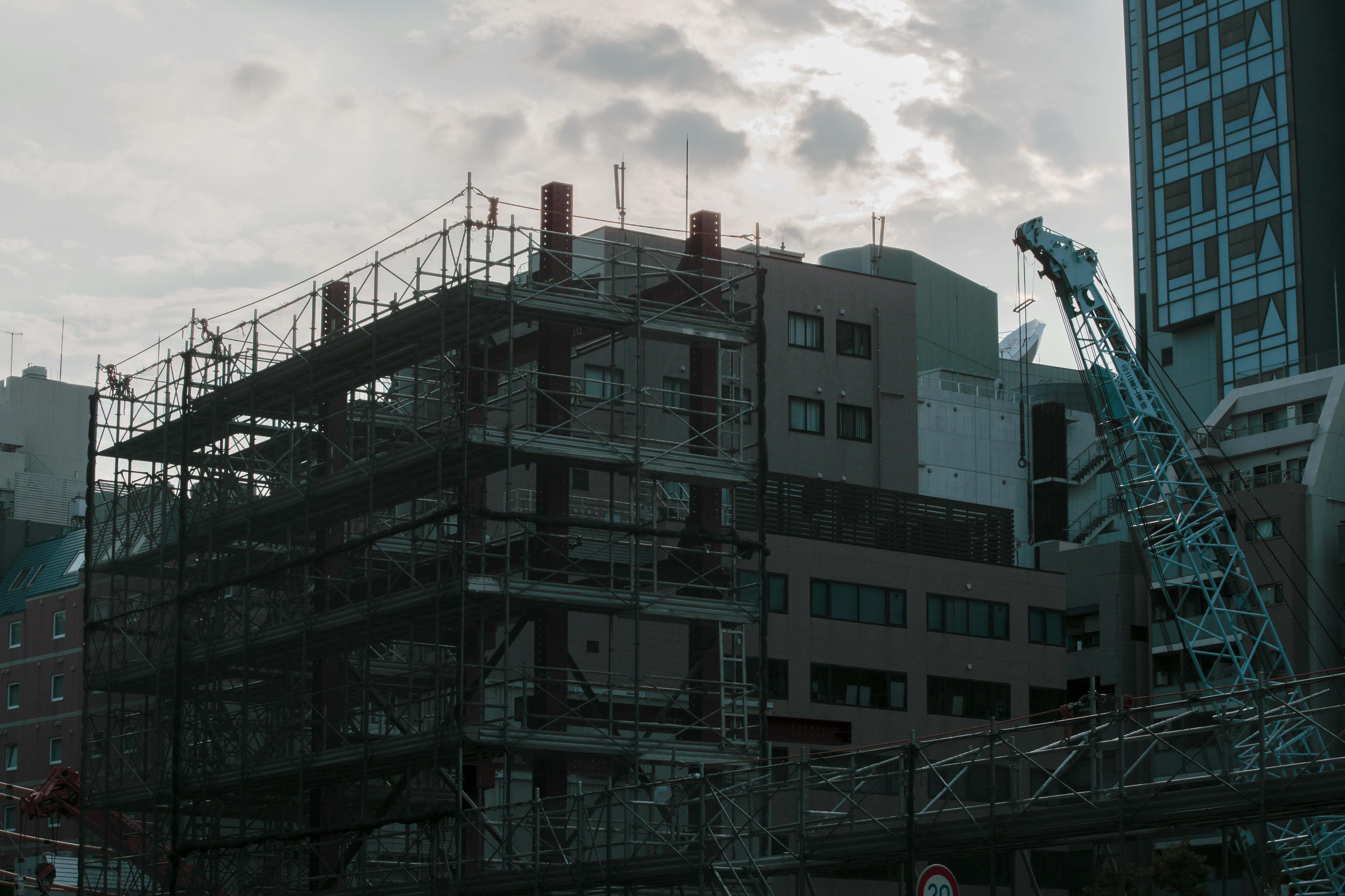 夕方の鉄骨建設現場の建造物とクレーン