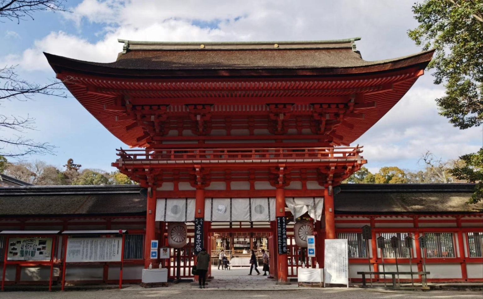 Entrance to a shrine featuring a striking red gate against a blue sky