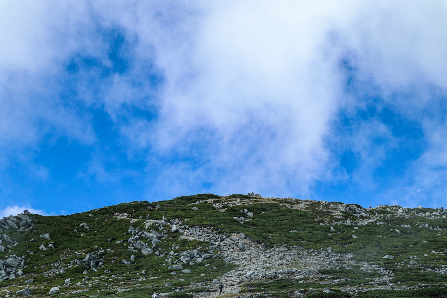 蓝天和云的山景 可见绿色山丘和岩石