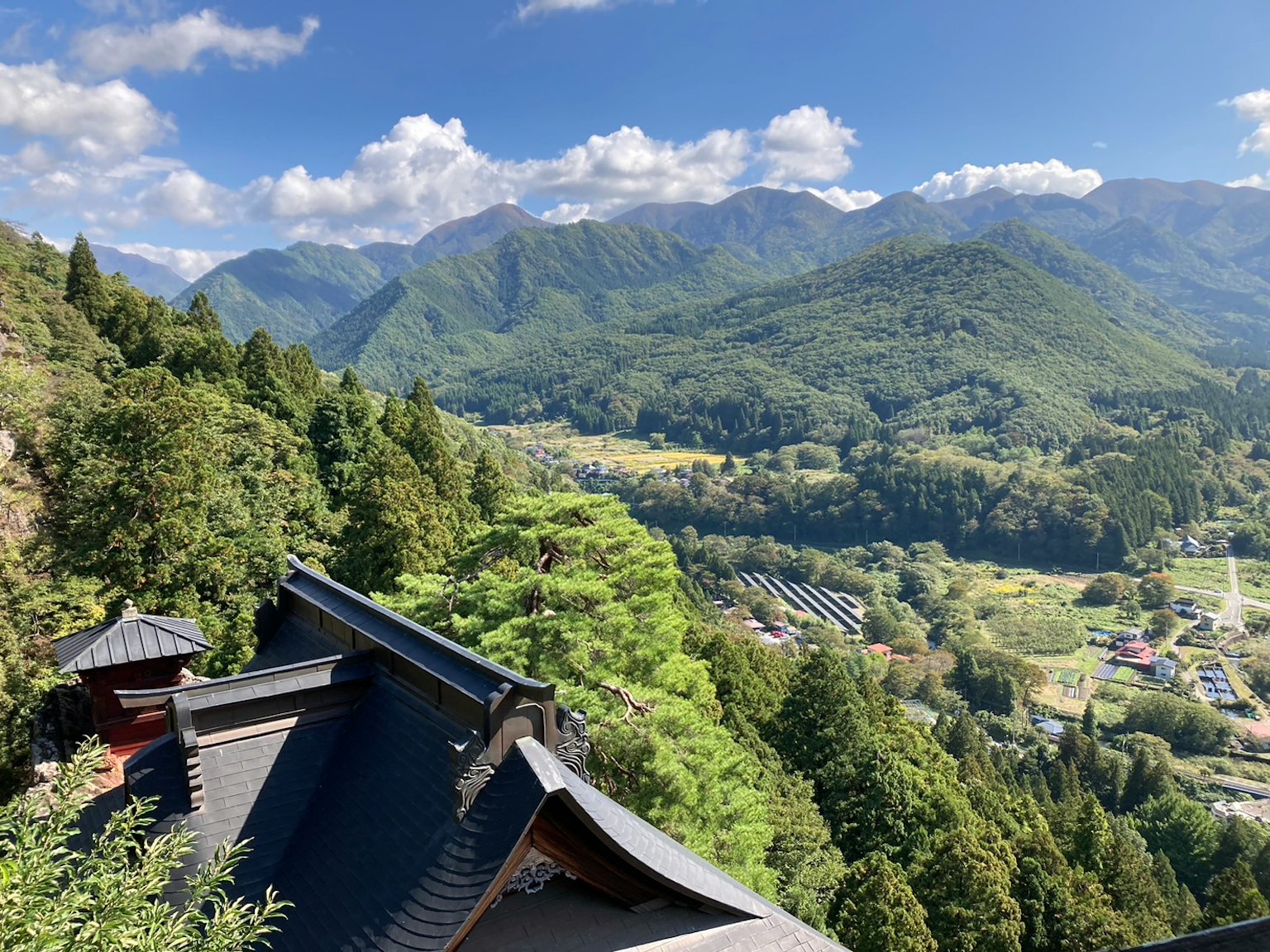 ทิวทัศน์ที่สวยงามของหลังคาวัดญี่ปุ่นที่อยู่ท่ามกลางภูเขาและต้นไม้