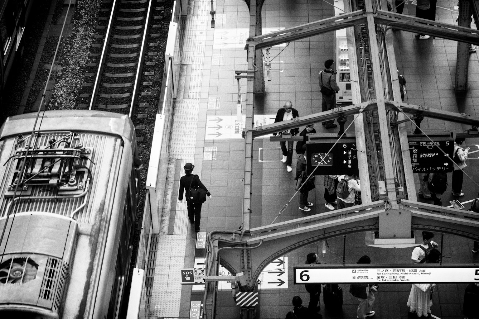 モノクロの駅の風景 鉄道とプラットフォームに人々がいる