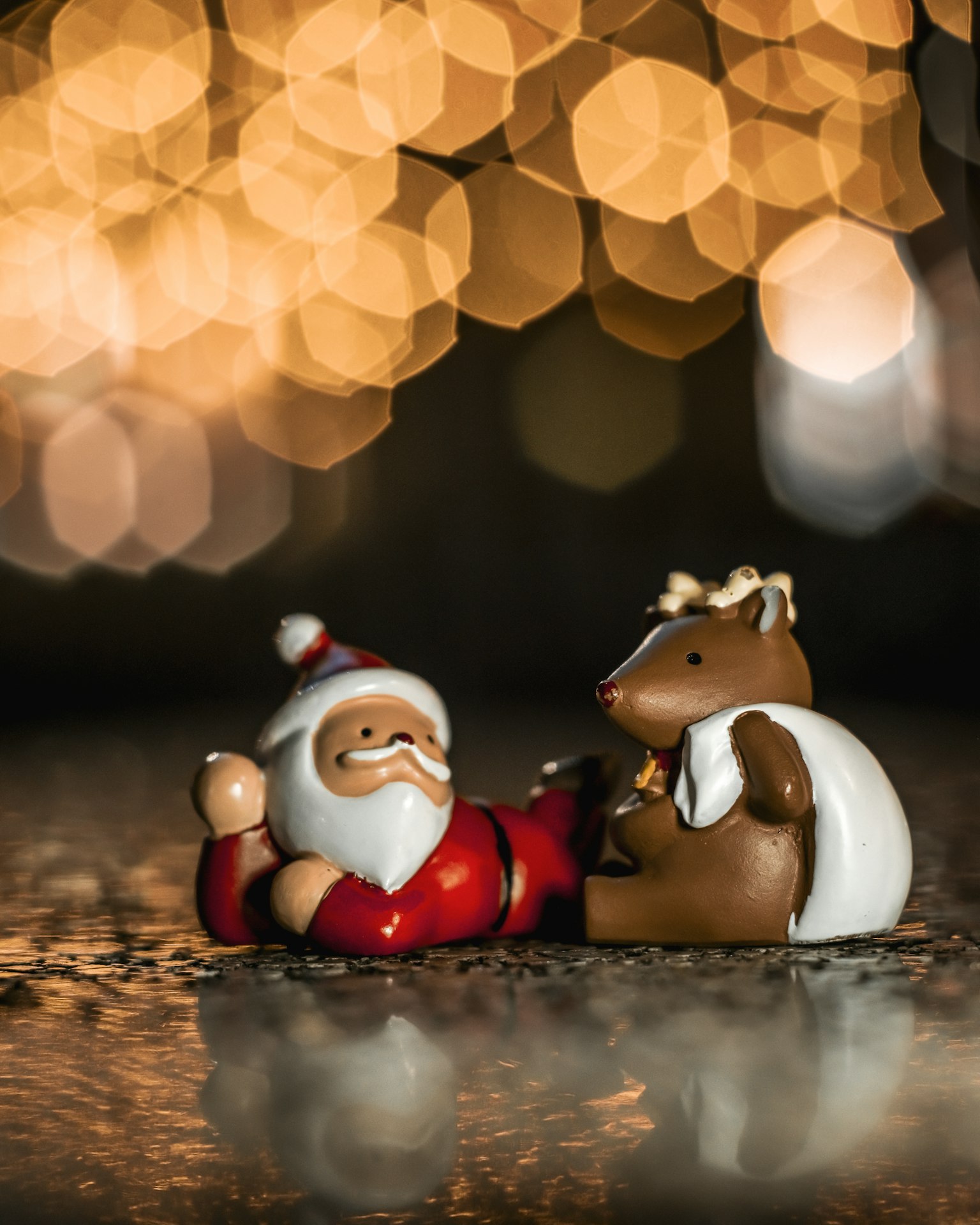 Ông già Noel và một bức tượng động vật nhỏ ngồi trước nền sáng