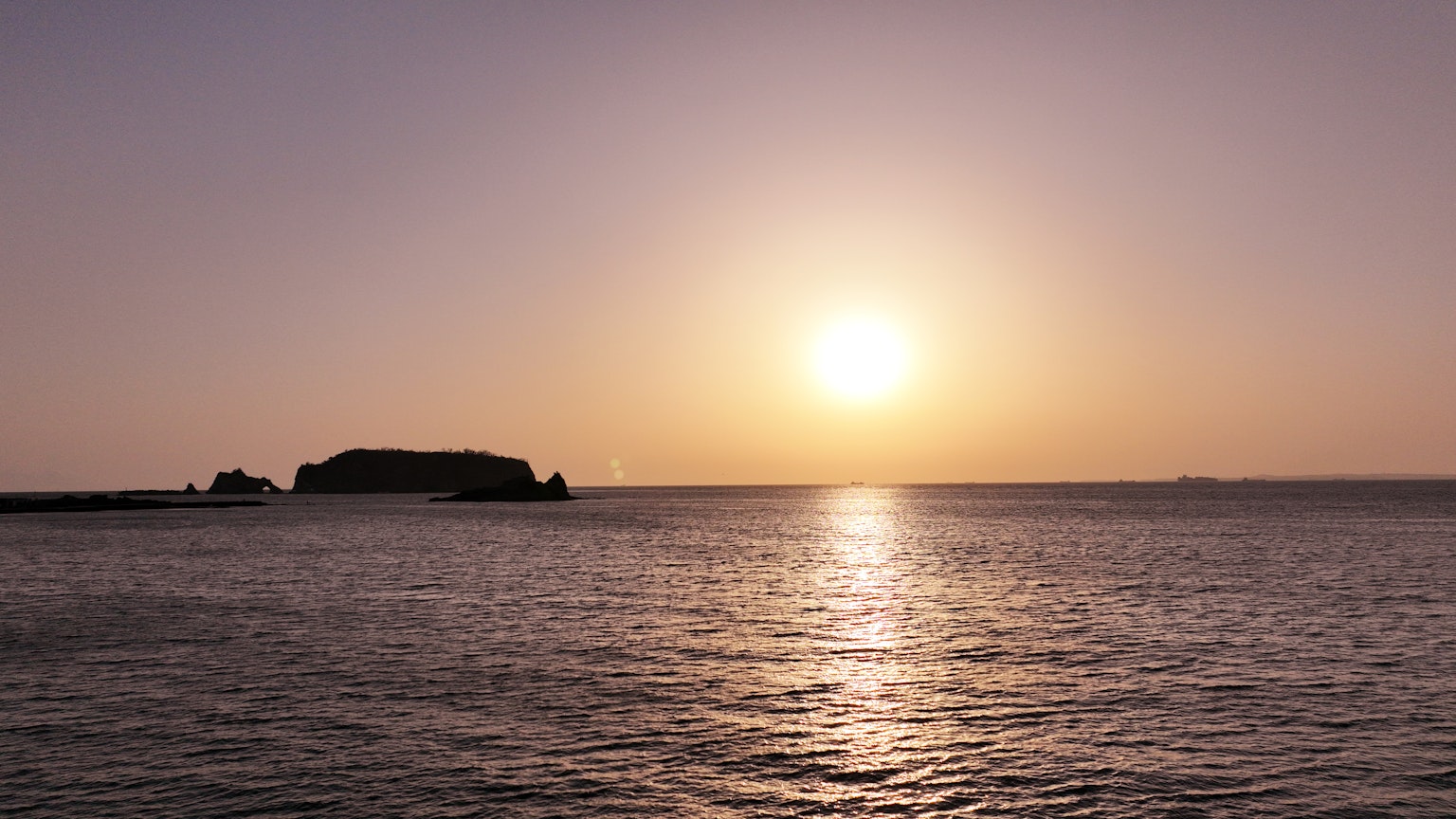 Un tranquillo tramonto sull'oceano con la silhouette di un'isola
