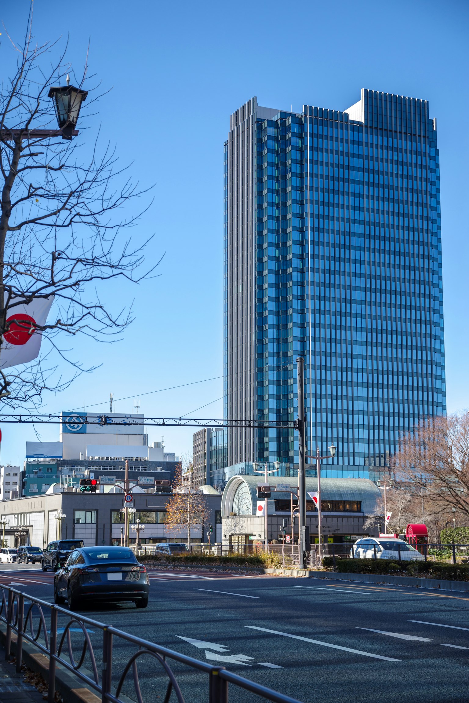 Un gratte-ciel moderne sous un ciel bleu clair avec un paysage urbain environnant