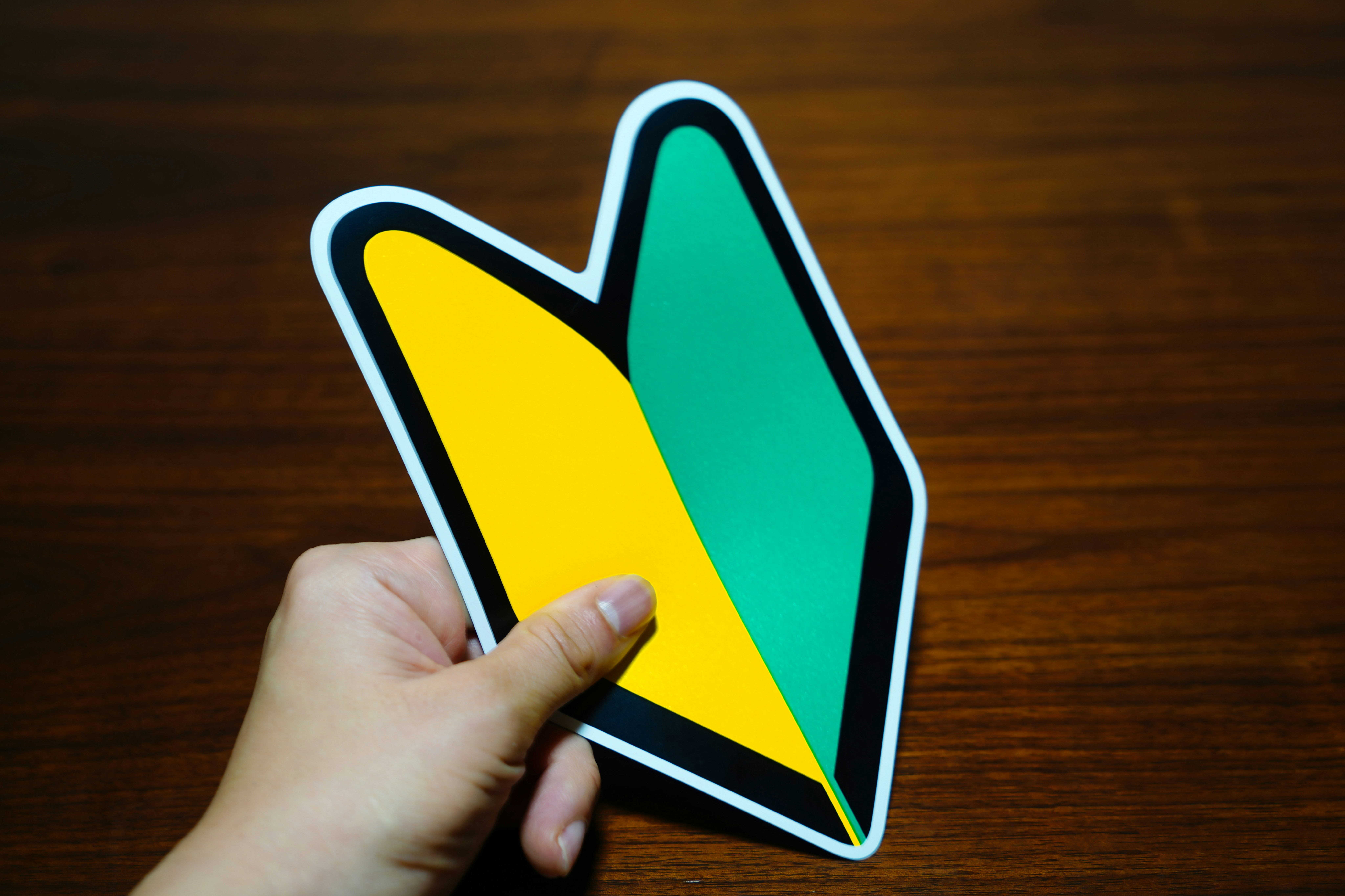 main tenant une icône d’application de carte sur un bureau en bois
