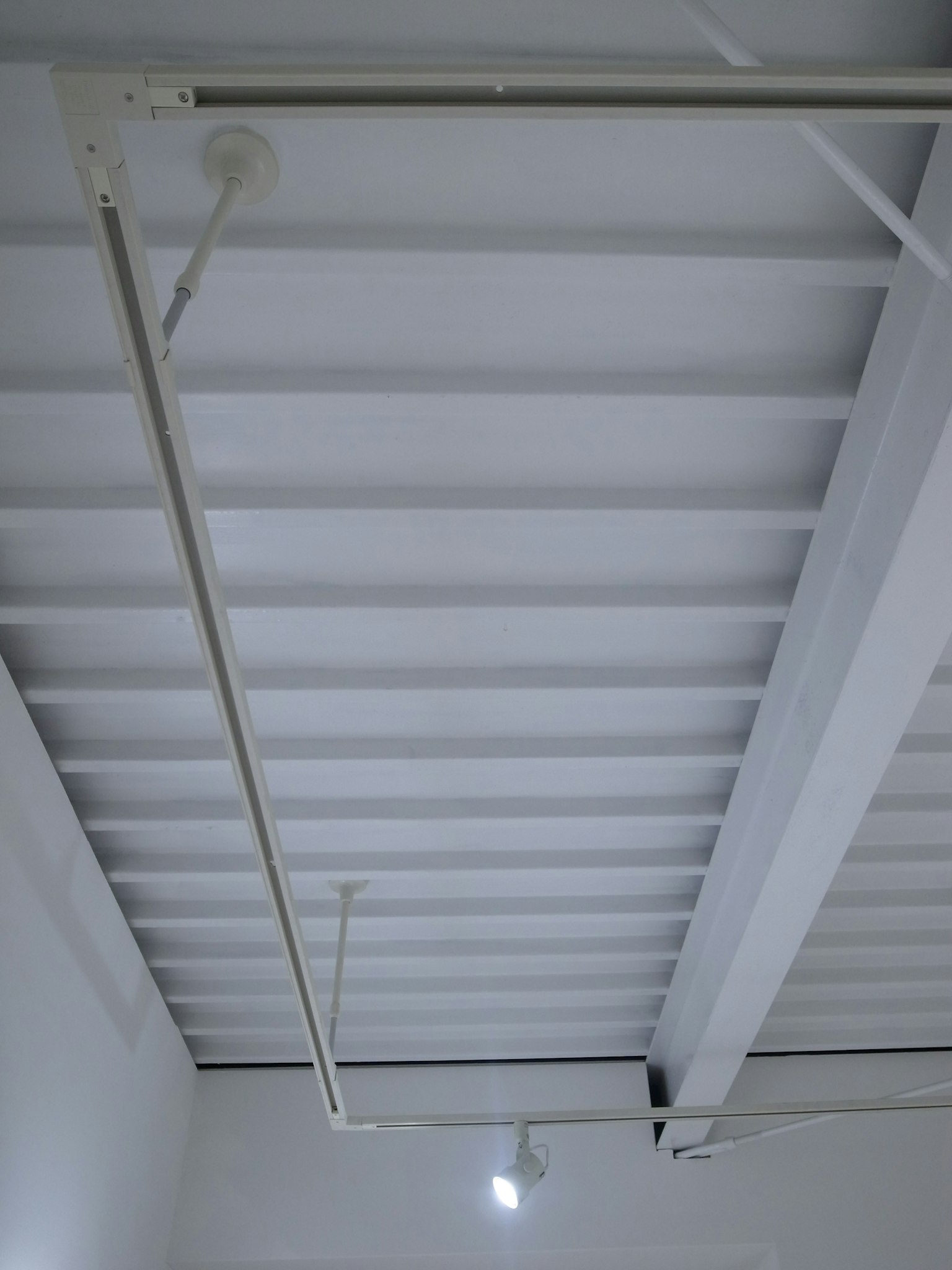 Tuberías de metal y luces montadas en un techo blanco