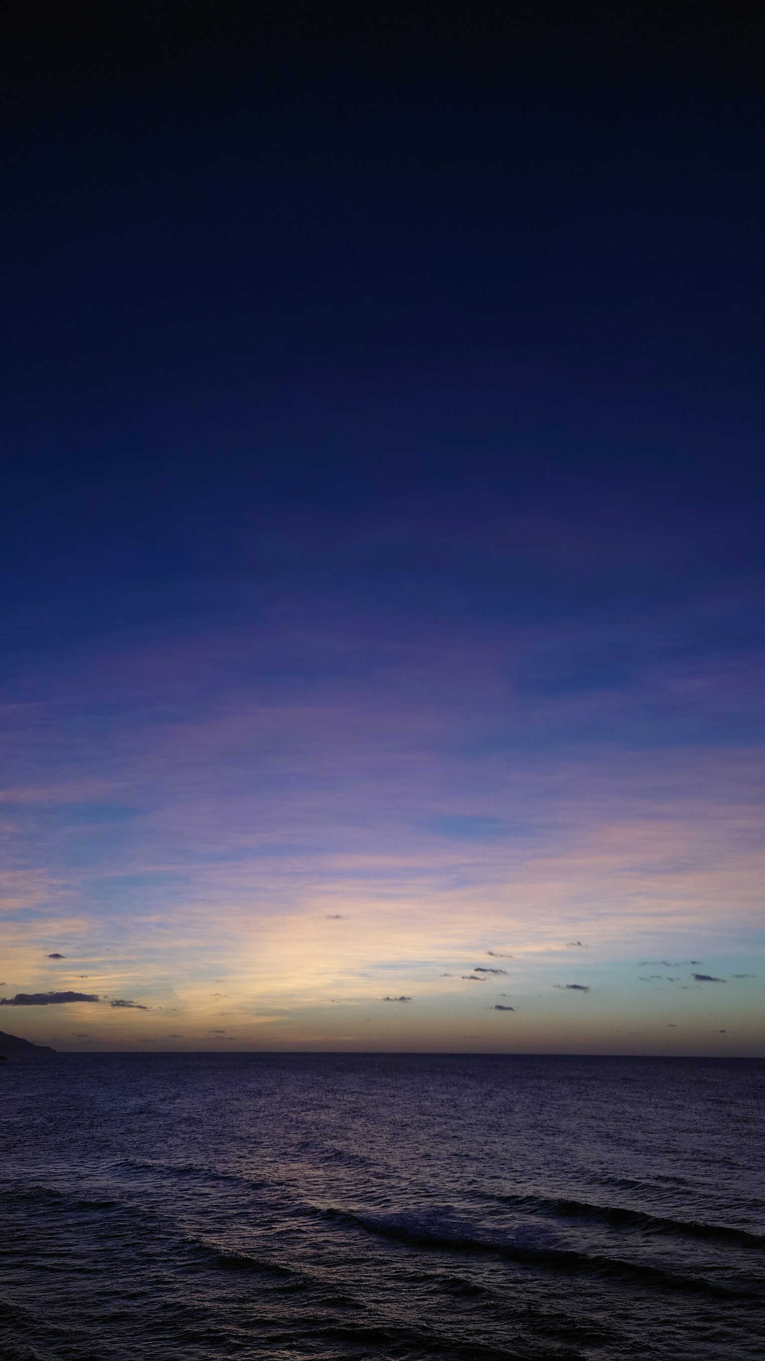 Paesaggio marino al crepuscolo con cielo blu e viola