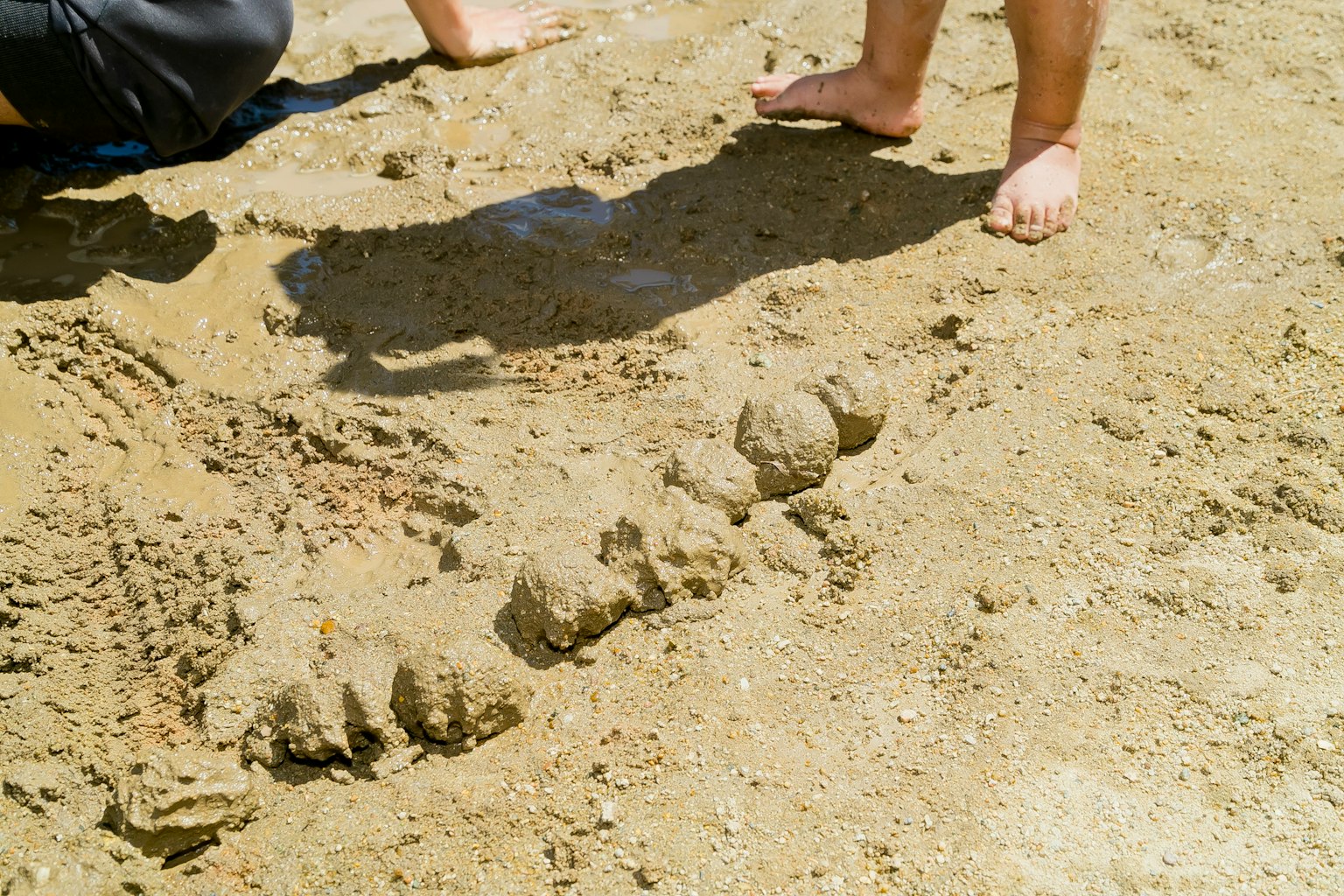 Une série de monticules de sable sur une plage avec des pieds nus à proximité