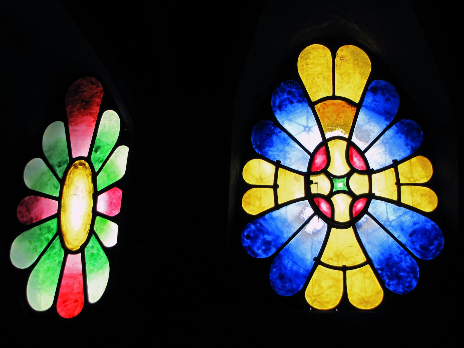 Fenêtres en vitrail coloré avec des motifs floraux sur fond noir