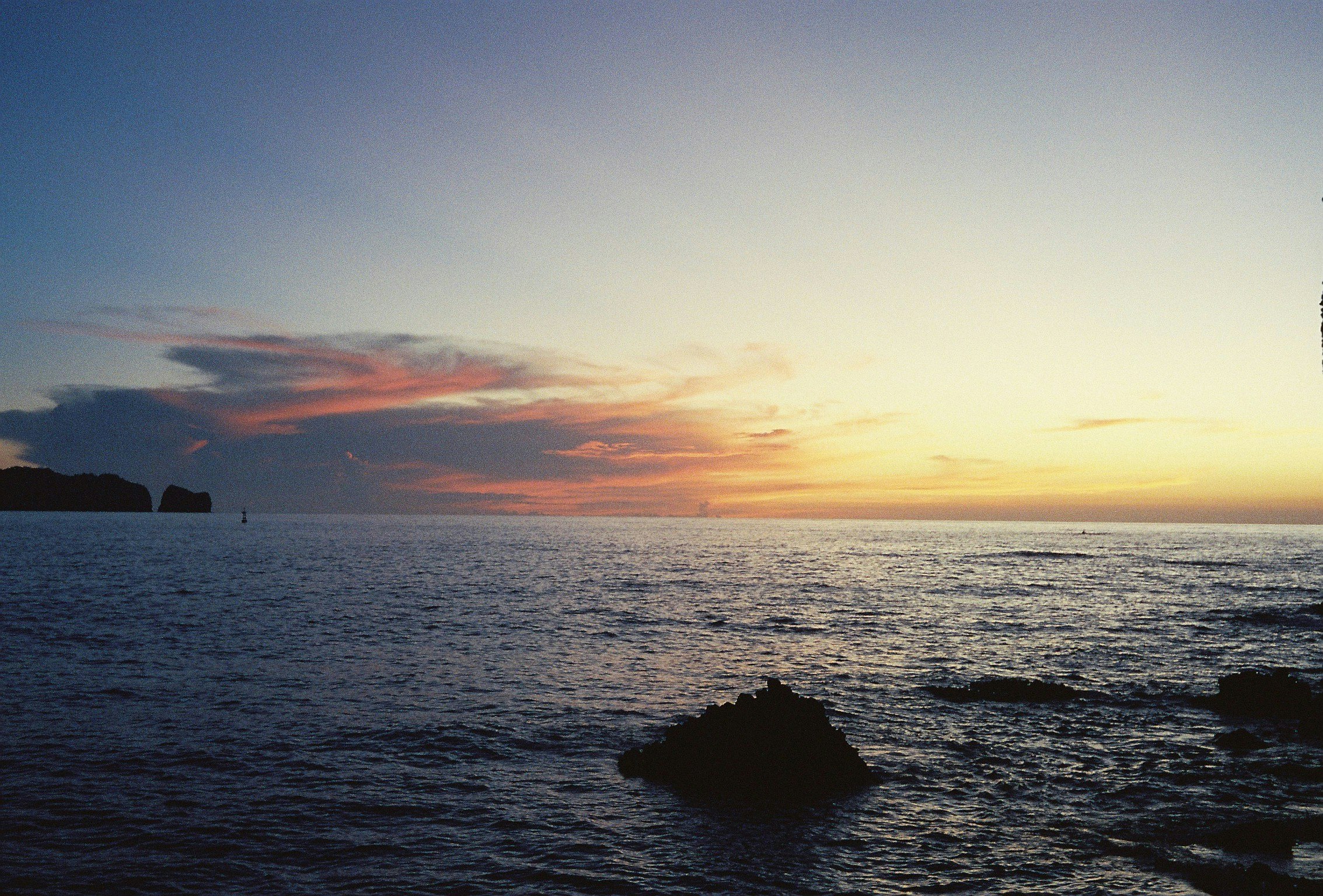 夕暮れの海と岩礁のある海岸風景