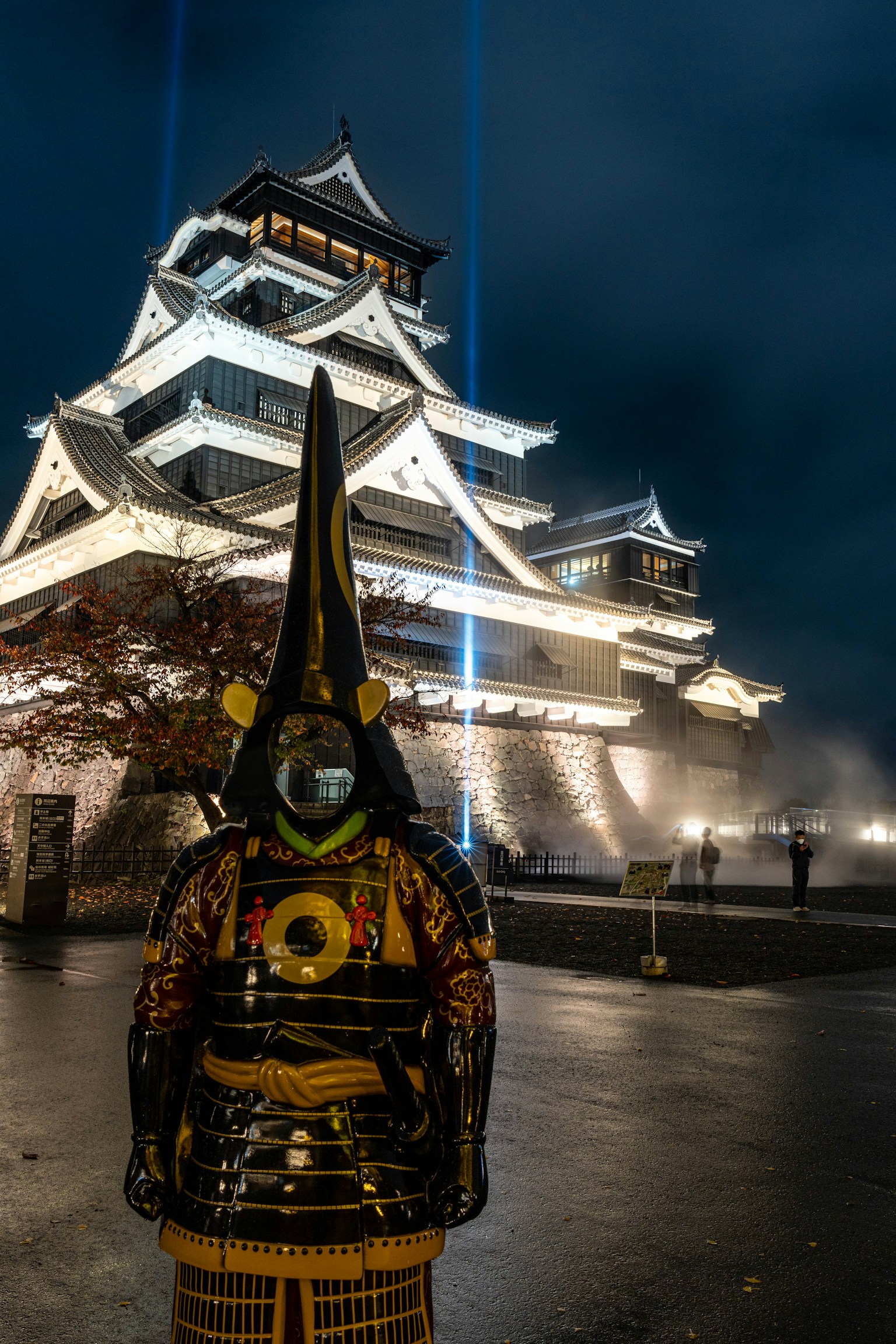 Kumamoto Castle at night with a samurai in traditional attire