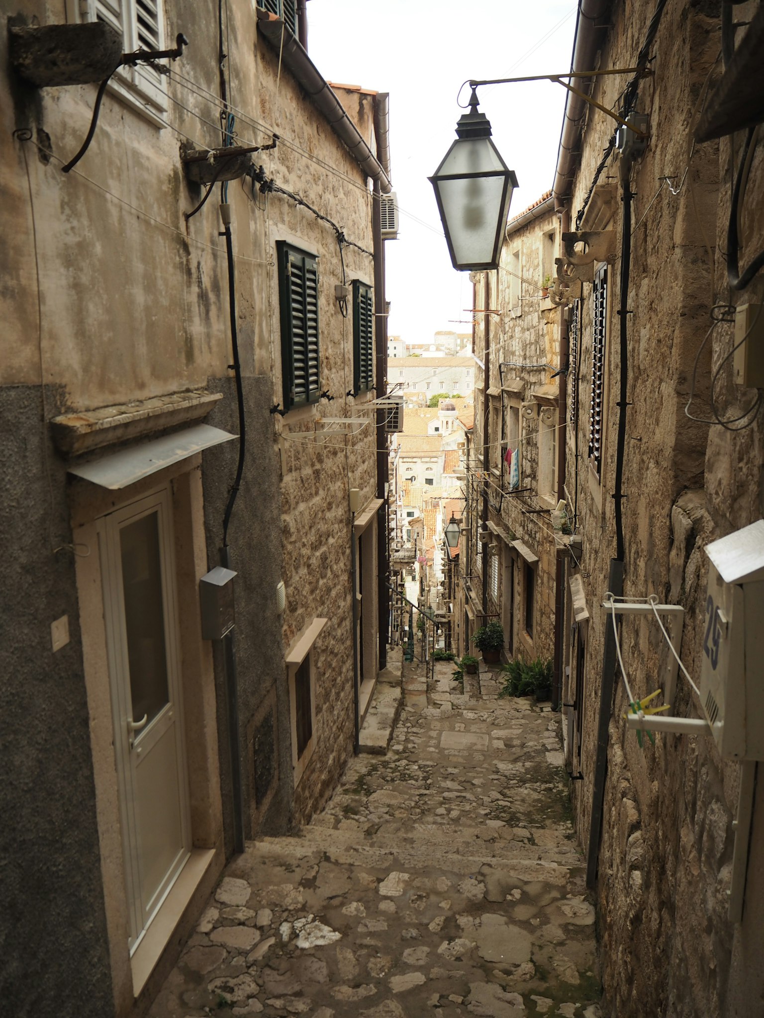 Callejón estrecho de piedras con edificios de piedra y farola
