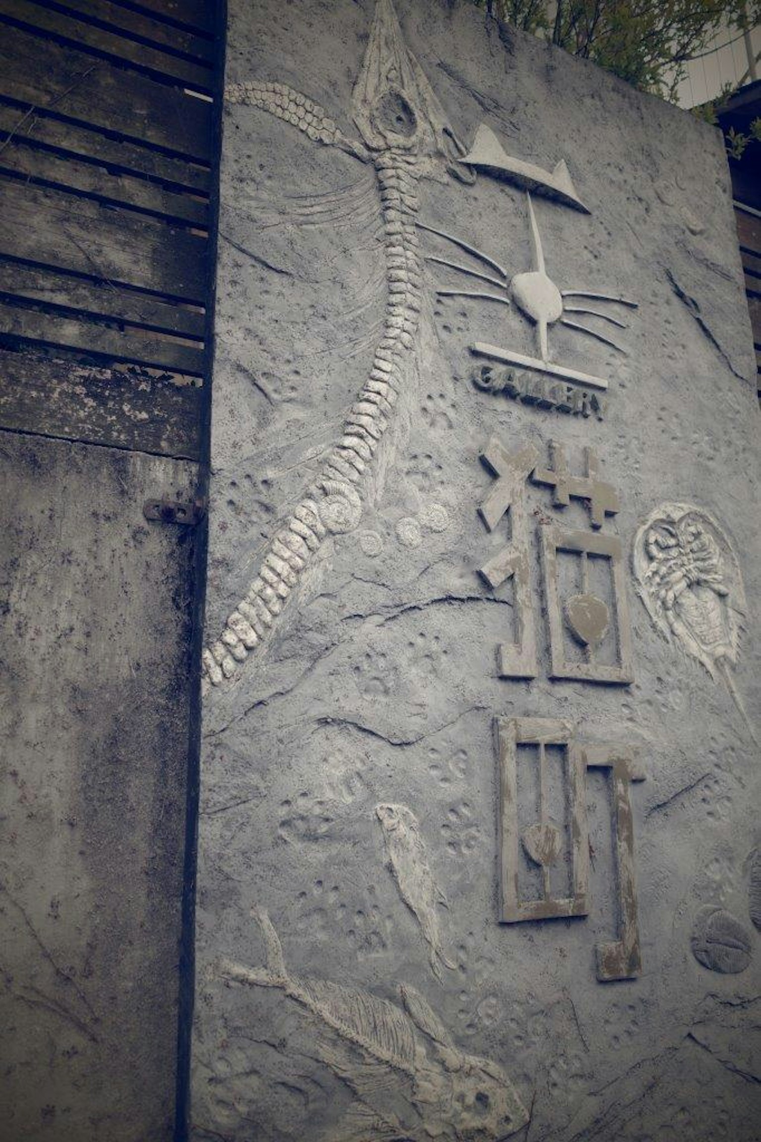 Carved stone panel featuring animal skeletons and inscriptions