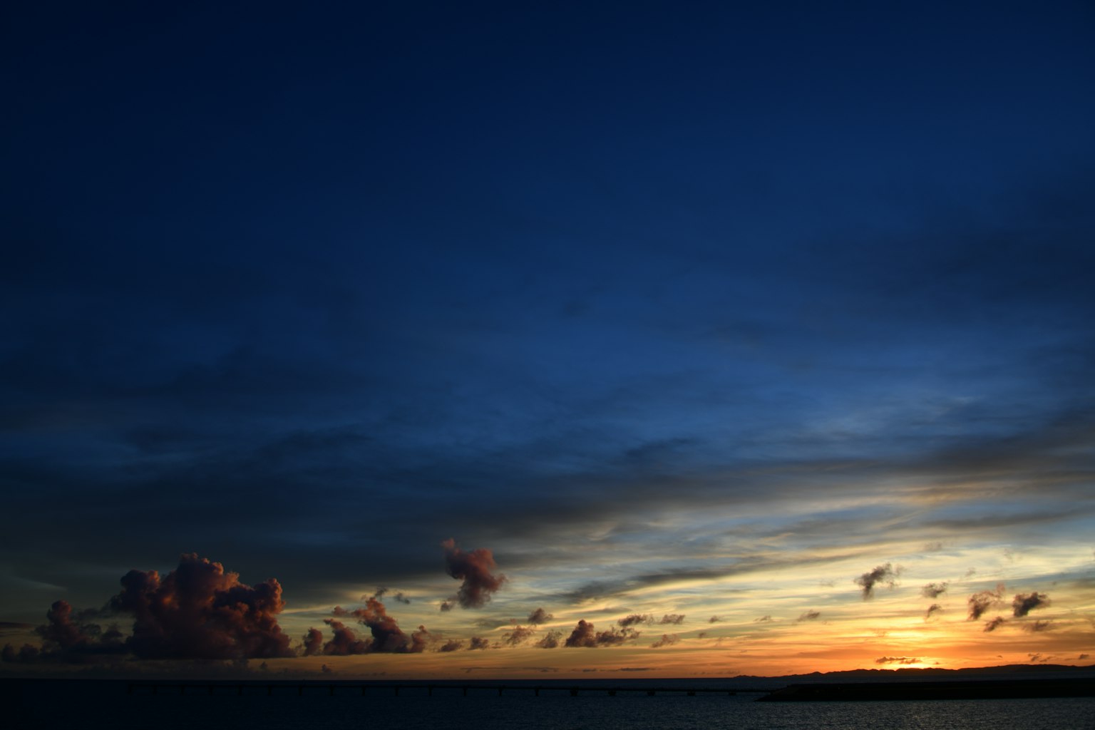 海上的日落，深藍色的天空和橙色的雲