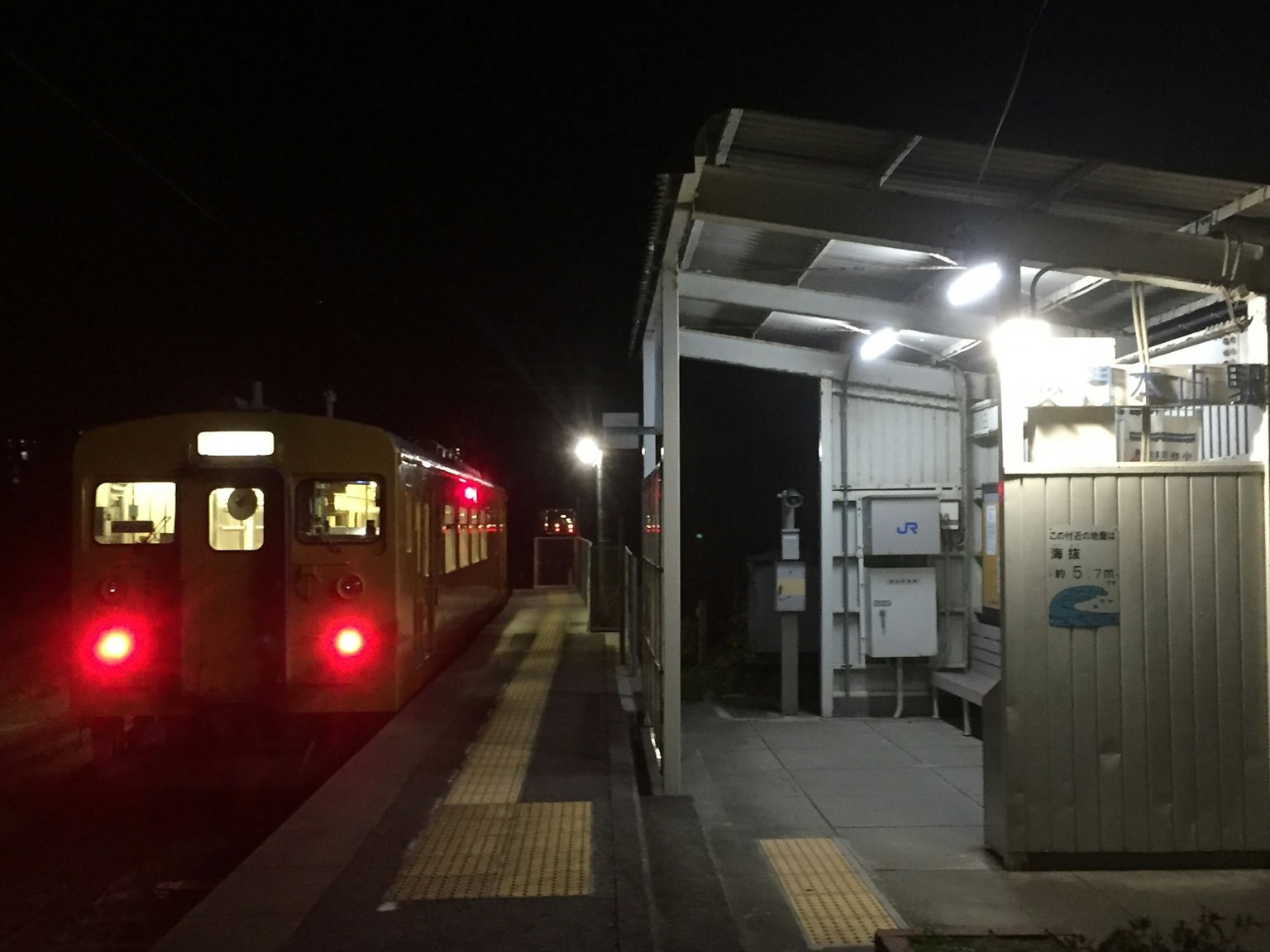 夜間停靠在車站的火車和明亮的站台燈光